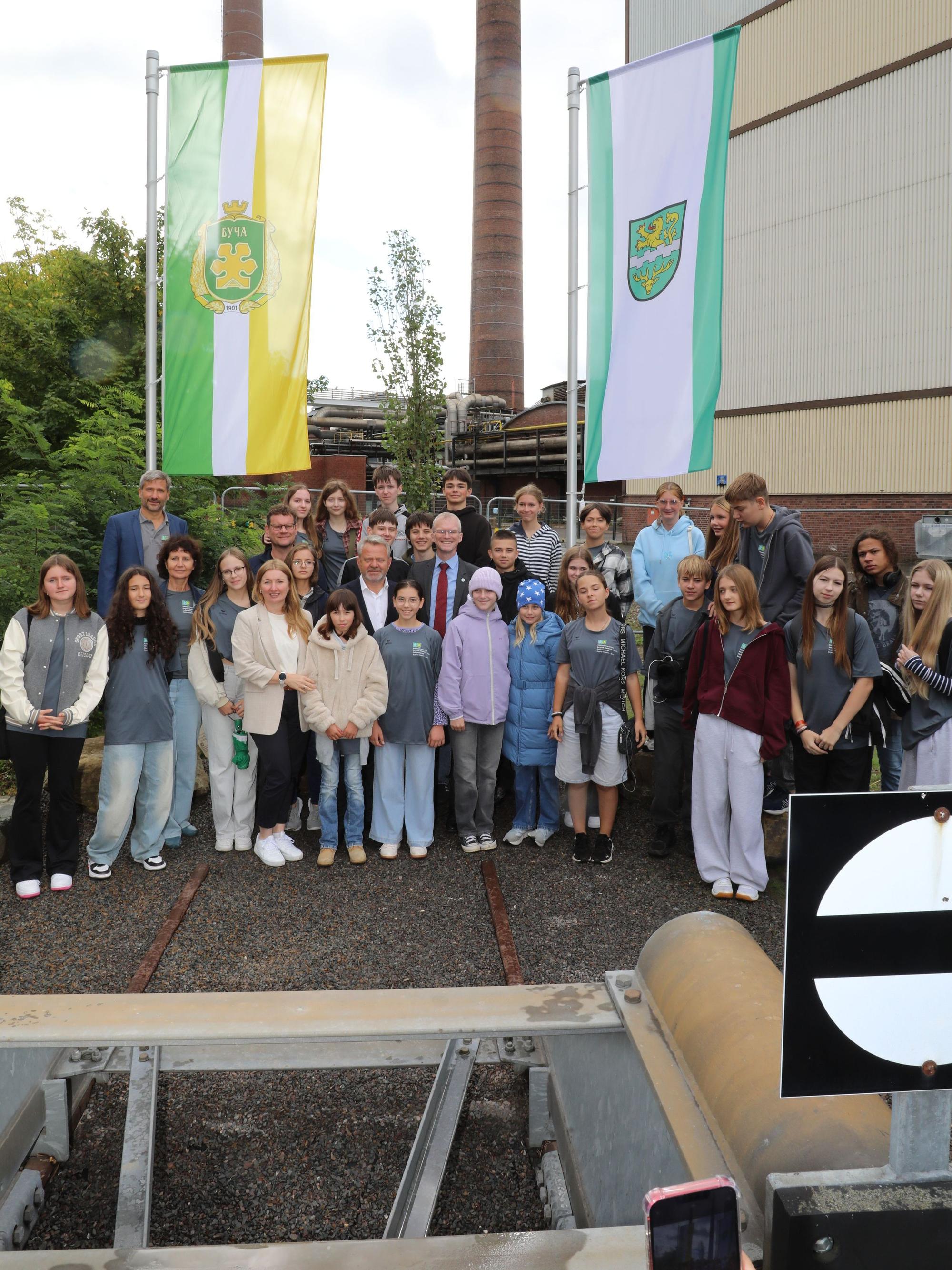 Schüler und Delegationsvertreter aus Butscha stehen am neuen Butscha-Platz in Bergisch Gladbach.