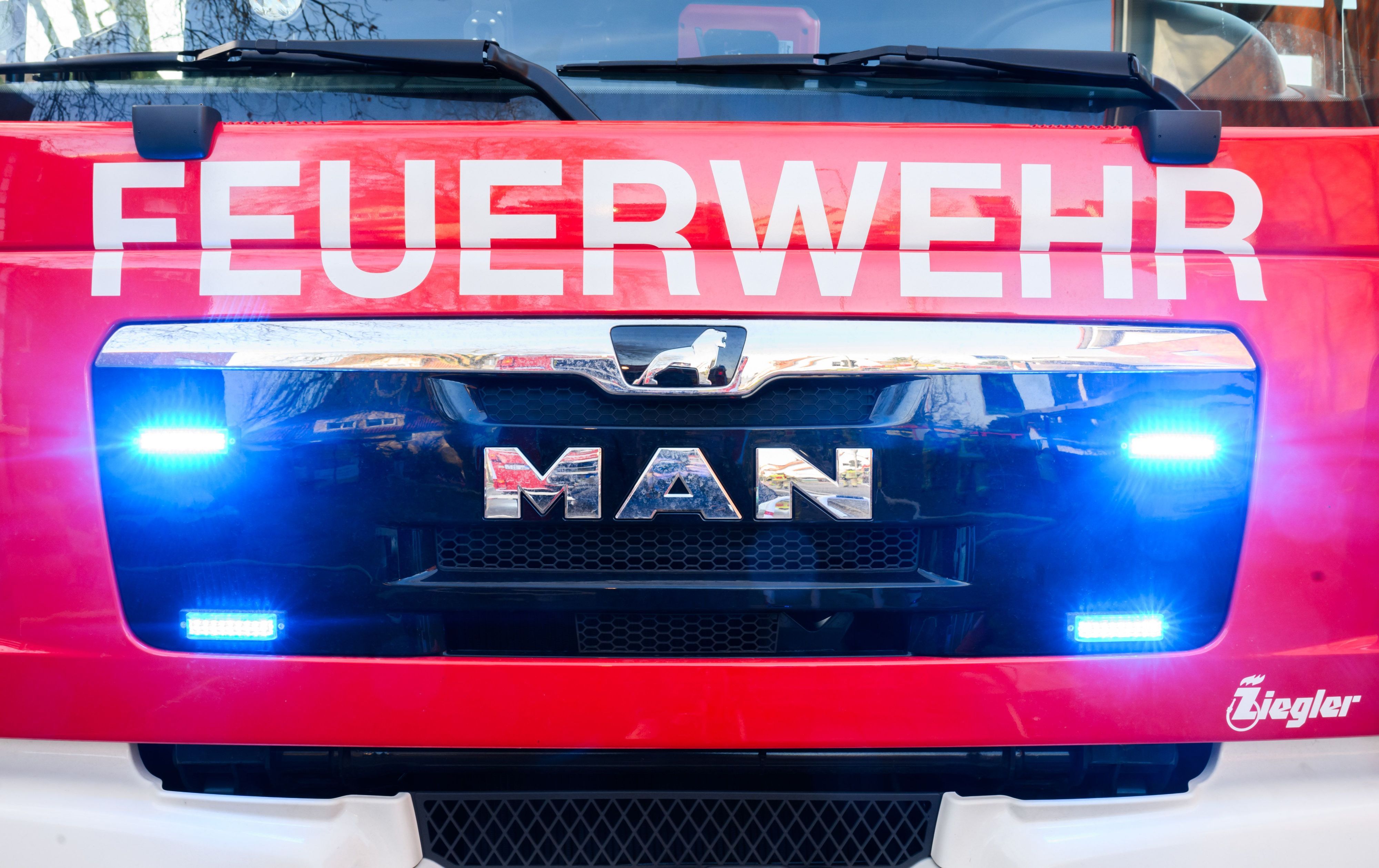 Blaulichter leuchten an einer Einsatzstelle an einem Löschfahrzeug der Feuerwehr.