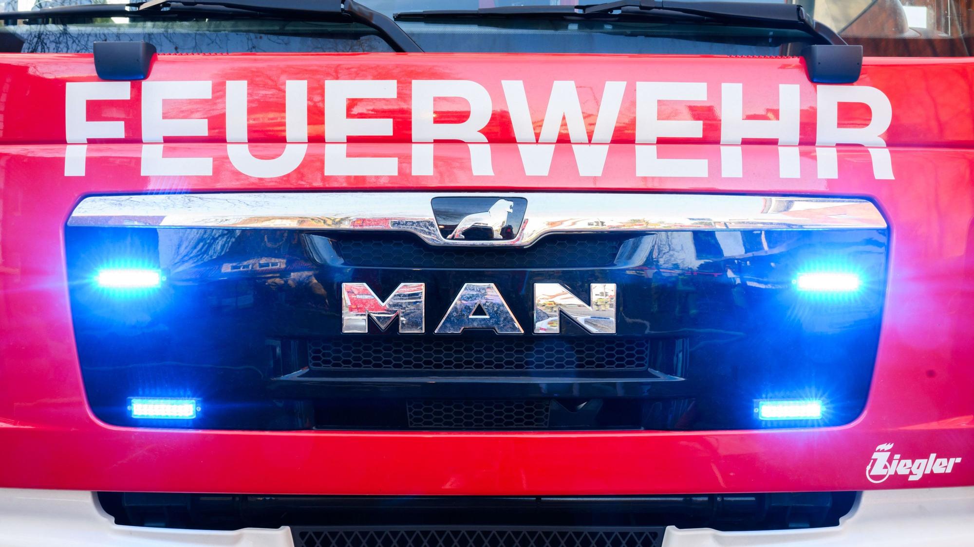 Blaulichter leuchten an einer Einsatzstelle an einem Löschfahrzeug der Feuerwehr.