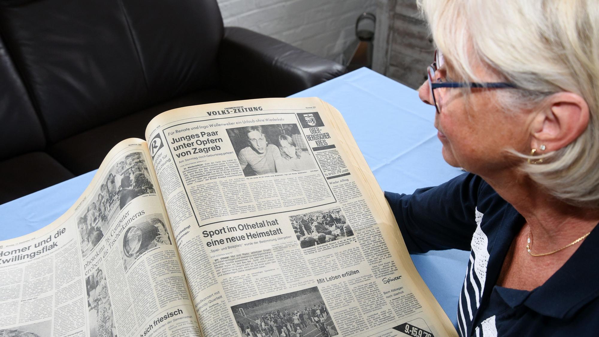 Eine Frau schaut auf einen alten Zeitungsartikel, in dem über einen Flugzeugabsturz vor 50 Jahren berichtet wird.