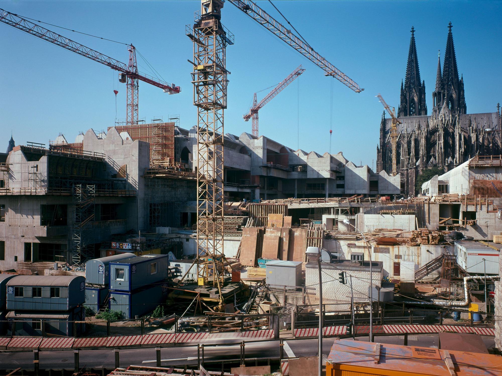 Baukräne stehen in einer Baugrube.