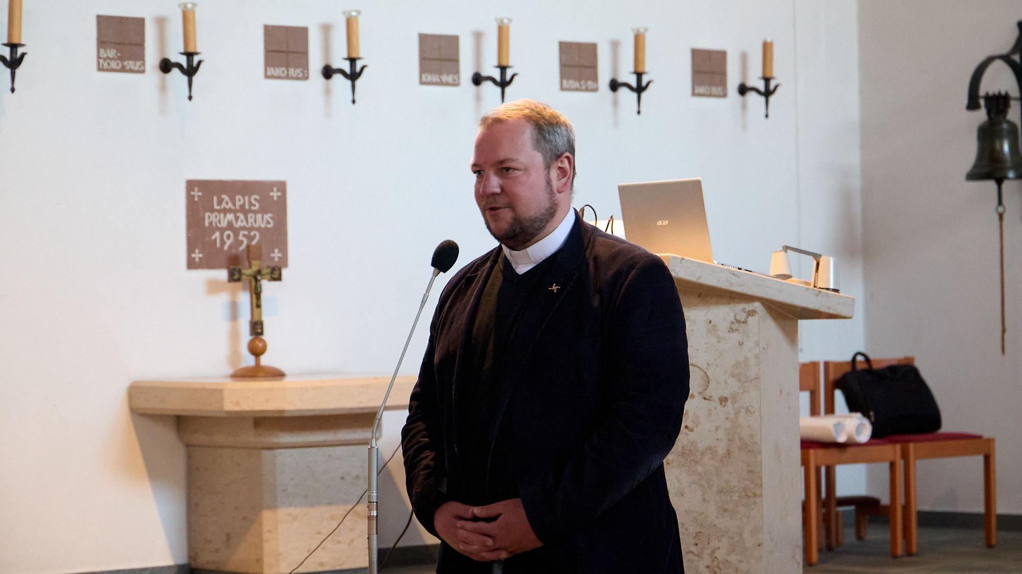 Der Pfarrer am Mikrofon.