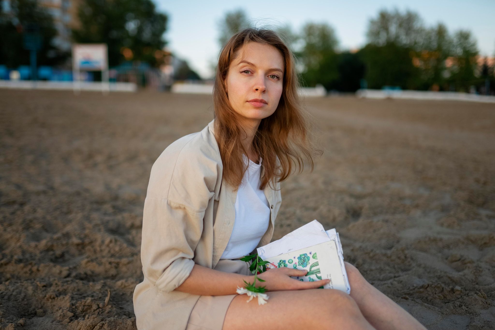 Eine Frau sitzt mit einem Buch am Strand