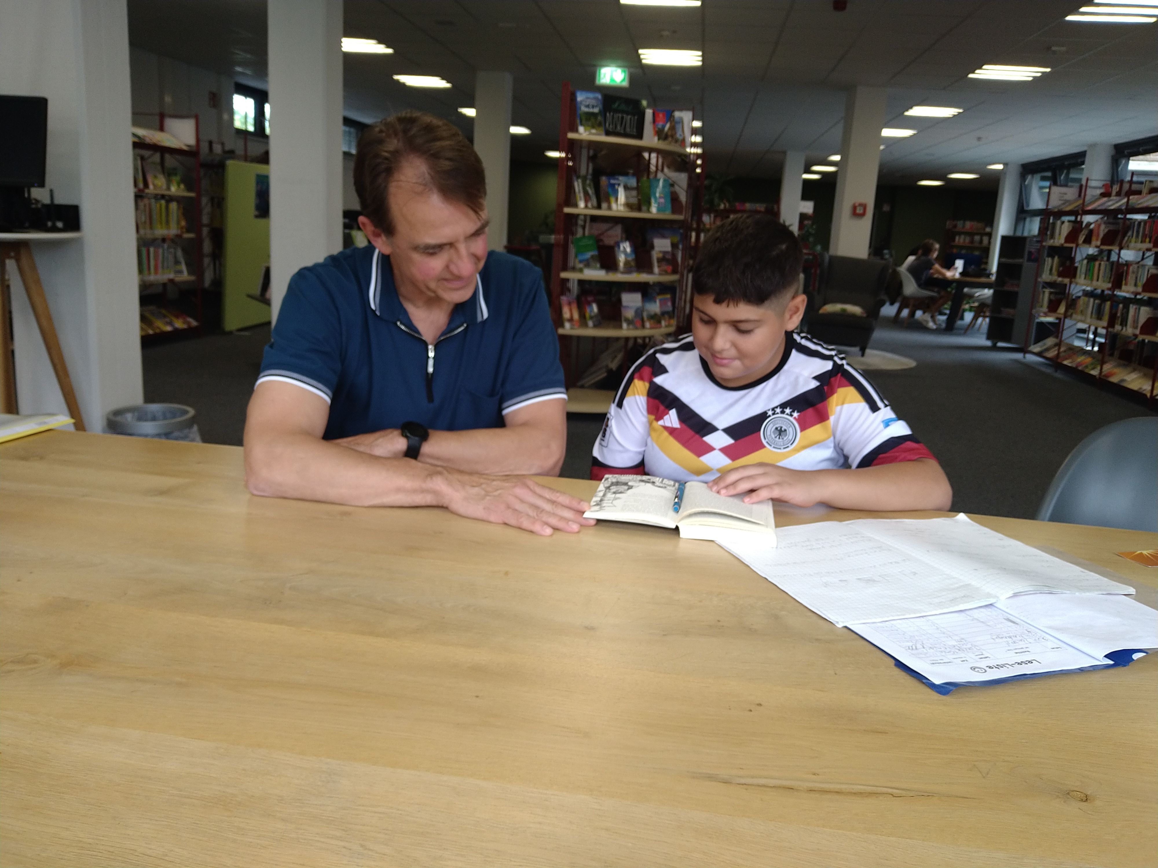 Schüler und Mentor beim gemeinsamen Lesen, Gruppenbild mit Vater: Andreas Urban, Musa Sabri, Alex Sabri