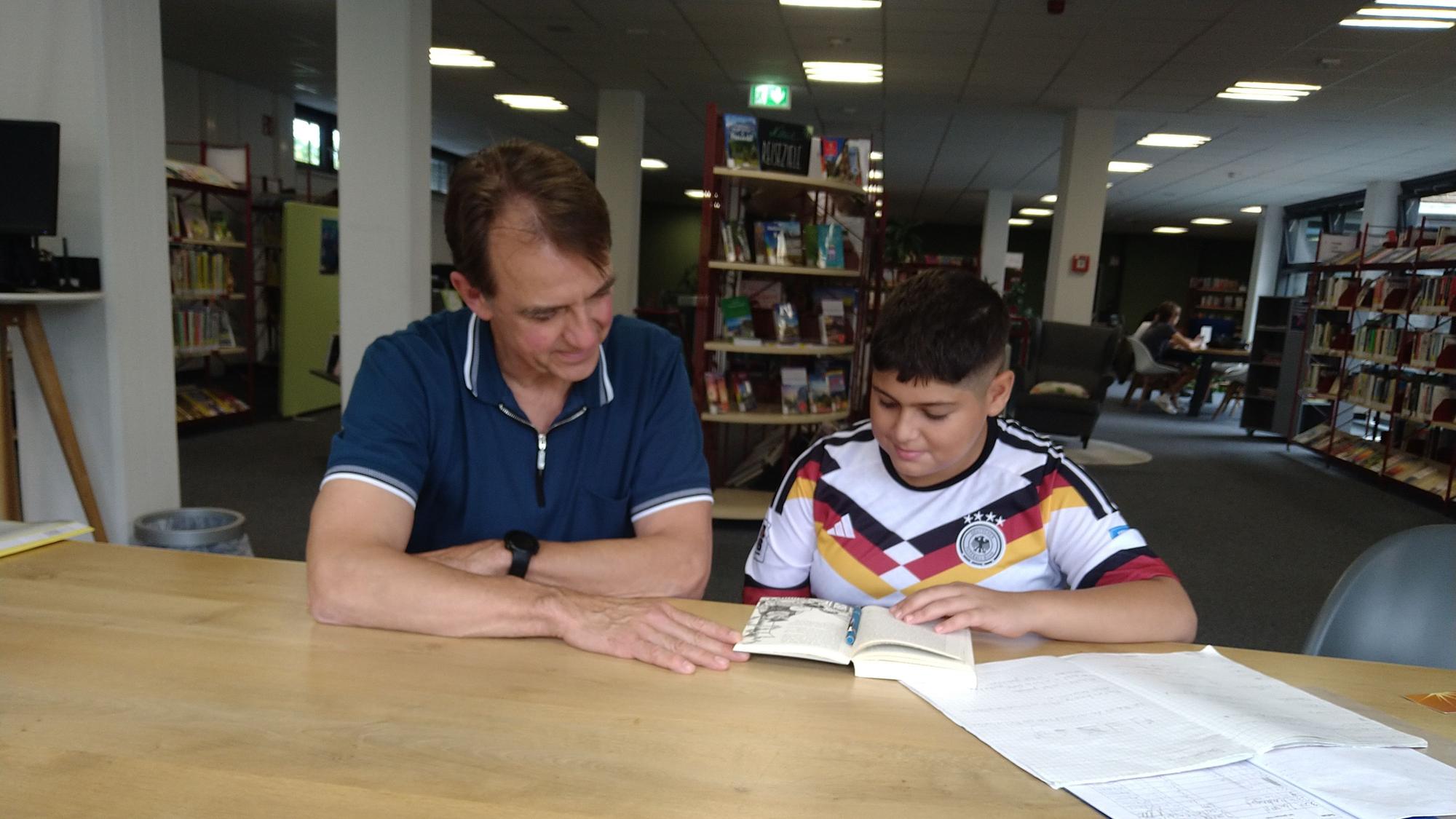 Schüler und Mentor beim gemeinsamen Lesen, Gruppenbild mit Vater: Andreas Urban, Musa Sabri, Alex Sabri