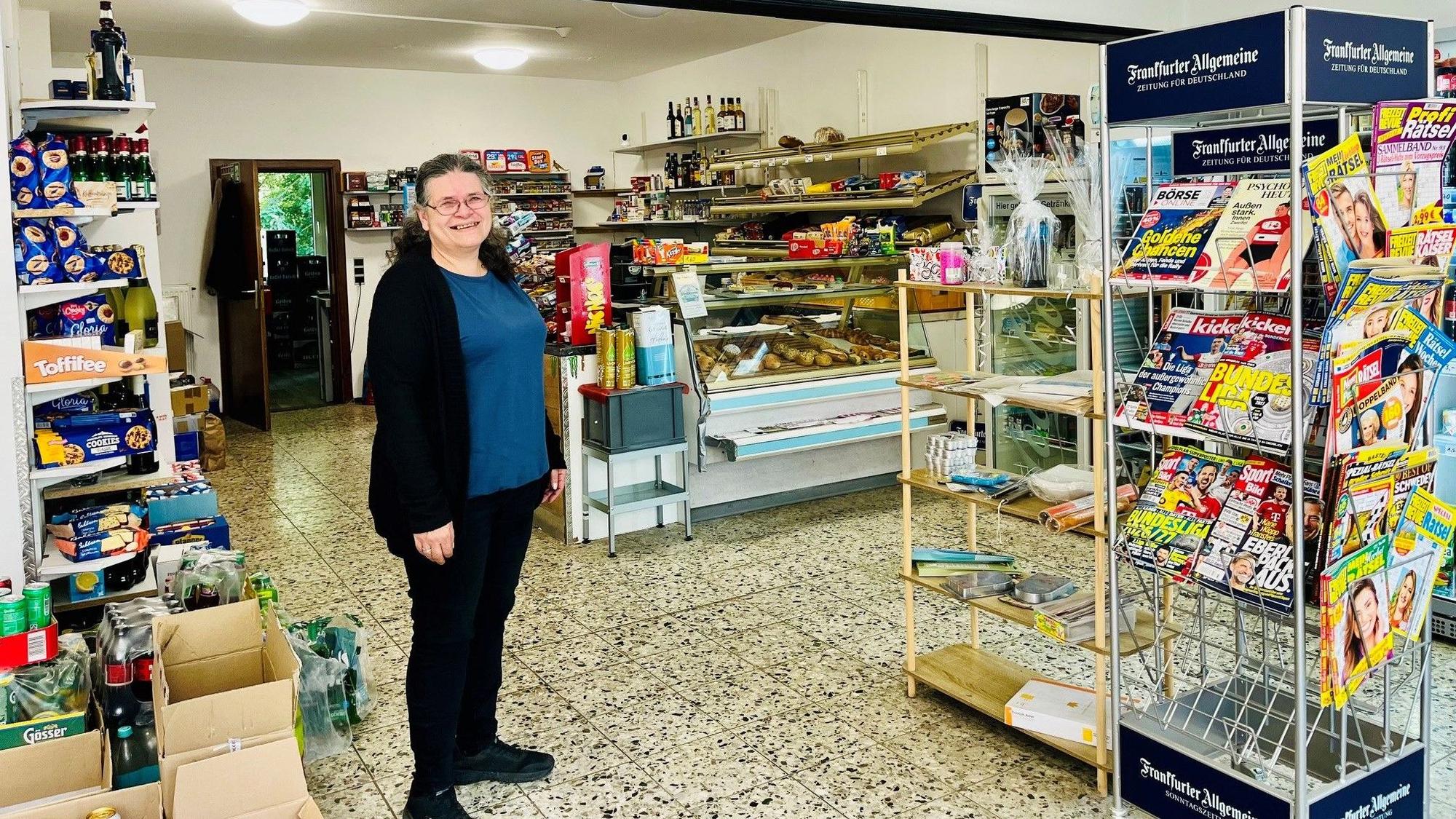 Die Frau steht vor ihrer Theke.