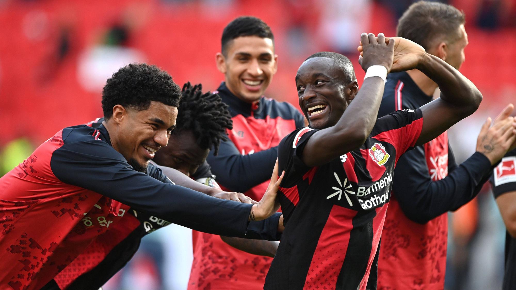 Leverkusens Malik Tilmann (l.) schubst Moussa Diaby (r.) freundschaftlich in Richtung Fankurve nach dem Spiel gegen Union Berlin.