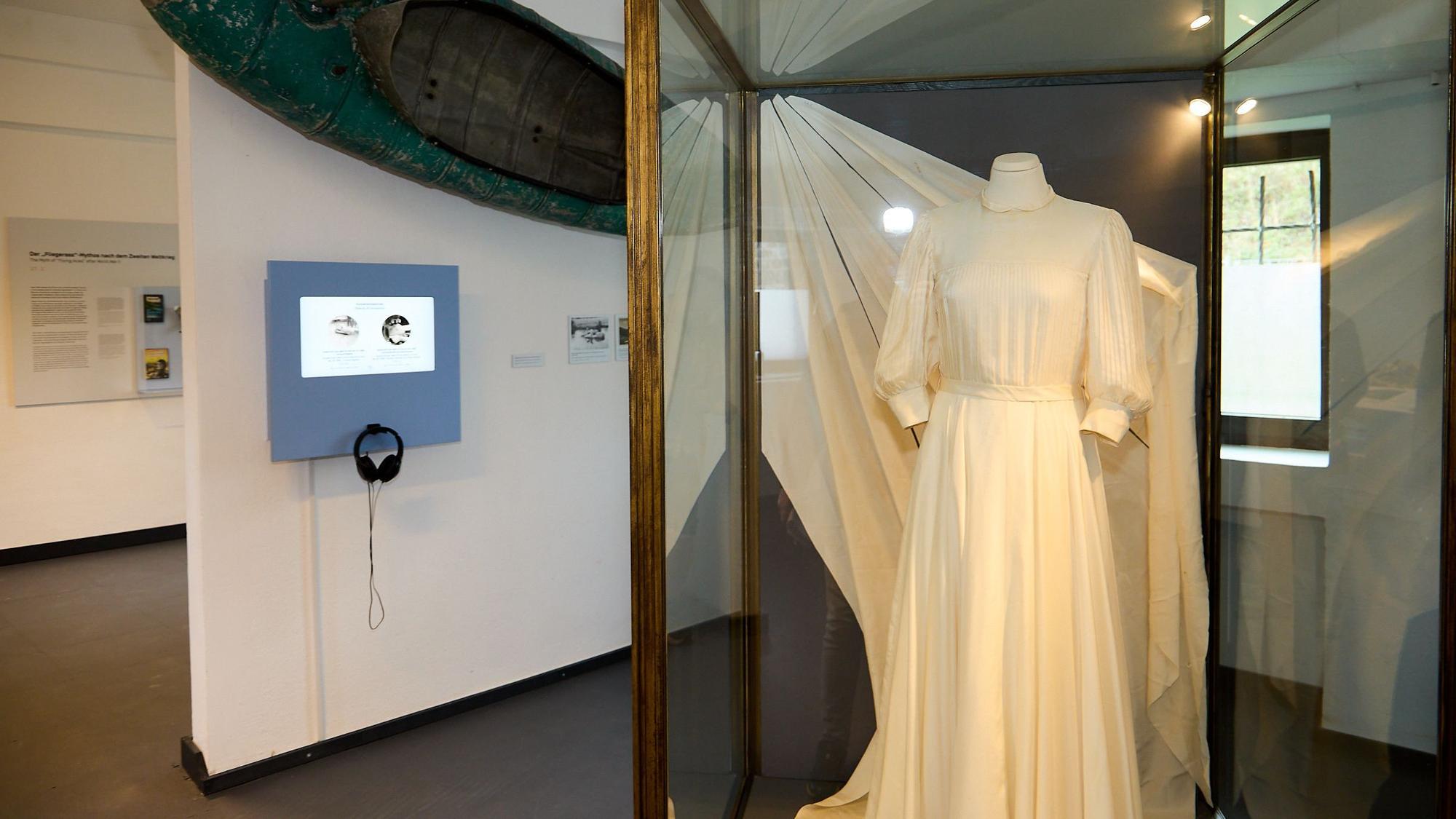Das Foto zeigt ein Hochzeitskleid aus Fallschirmseide und ein Kanu aus einem Abwurftank.