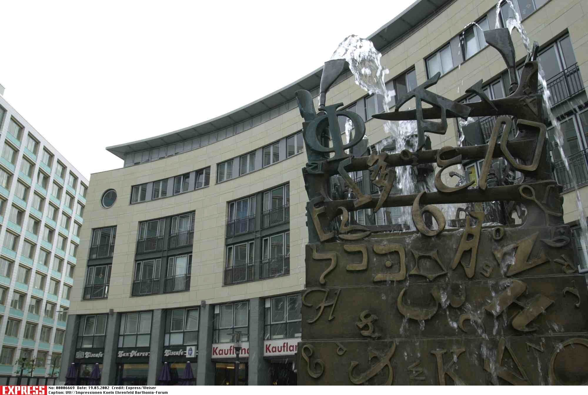 Ein Brunnen steht vor einem großen Gebäudekomplex.