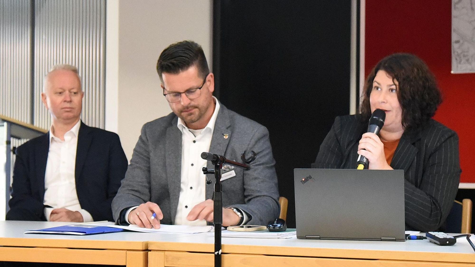 Drei Personen auf einem Podium.