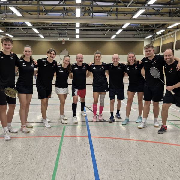 Die Badmintonspieler aus Kall stehen in einer Sporthalle.