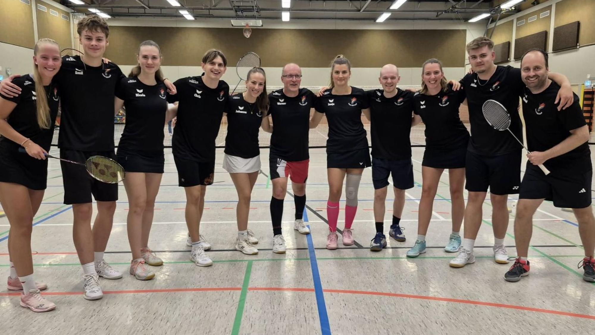 Die Badmintonspieler aus Kall stehen in einer Sporthalle.