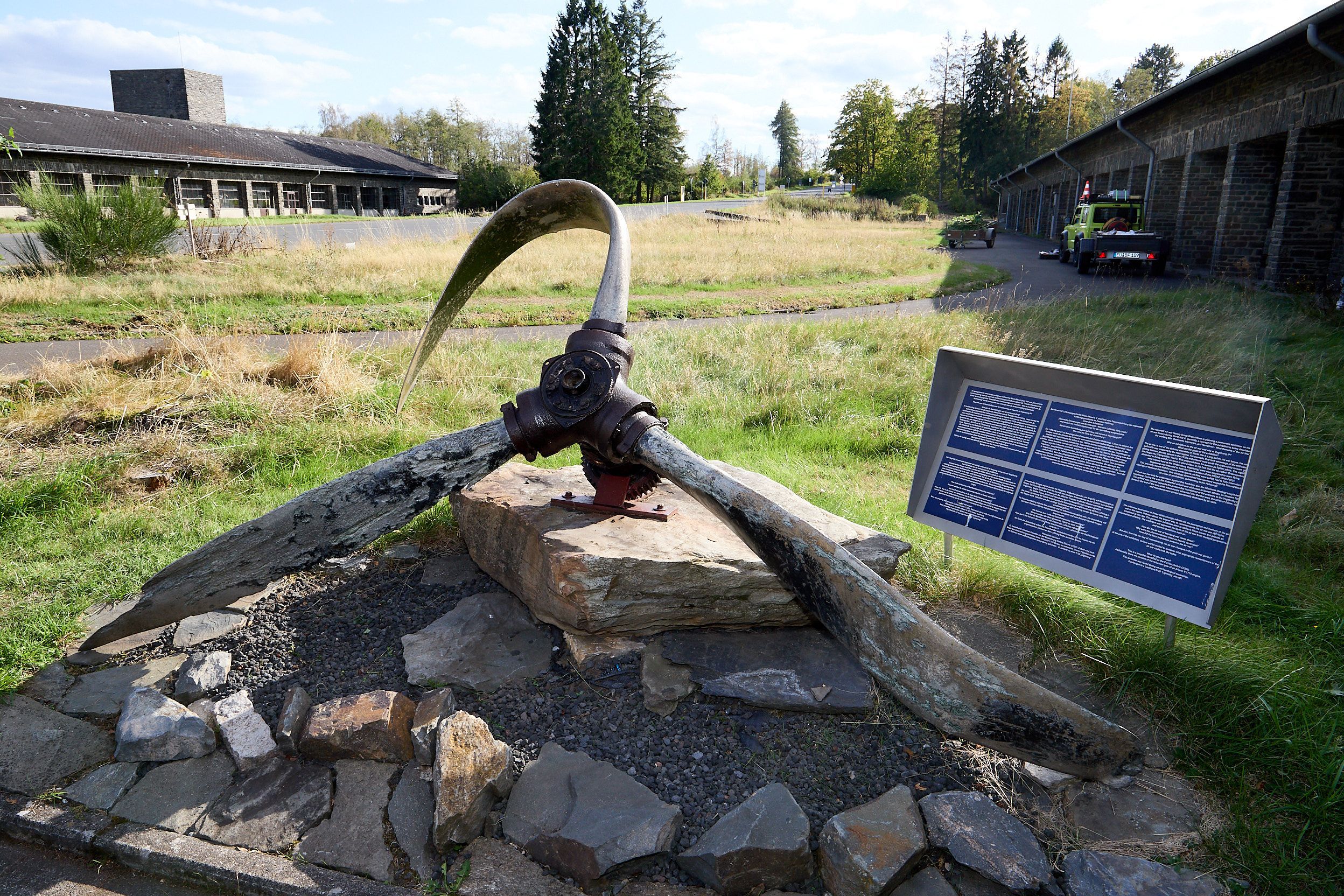 Ein verbogener Propeller einer P38 Lightning liegt auf einem großen Stein.