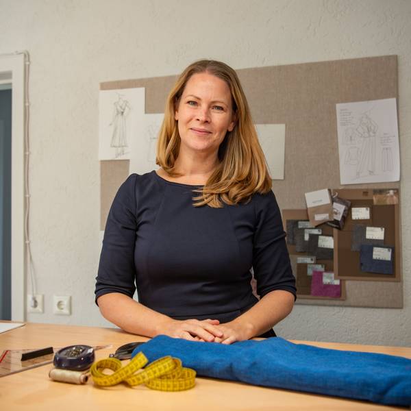 Stefanie Behling steht hinter einer Ladentheke, darauf liegen Näh-Utensilien.