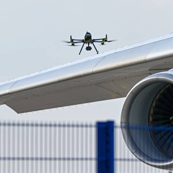 Eine Drohne der Polizei ist über einer Flugzeugtragfläche zu sehen.