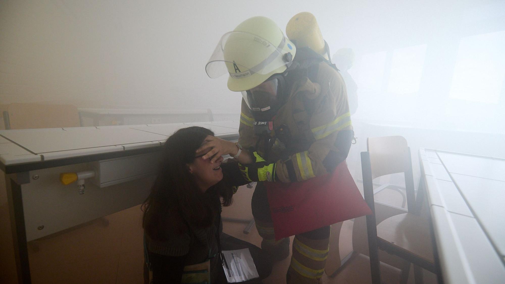 Im Nebel hat ein Feuerwehrmann eine Verletzten gefunden und bringt sie in Sicherheit.
