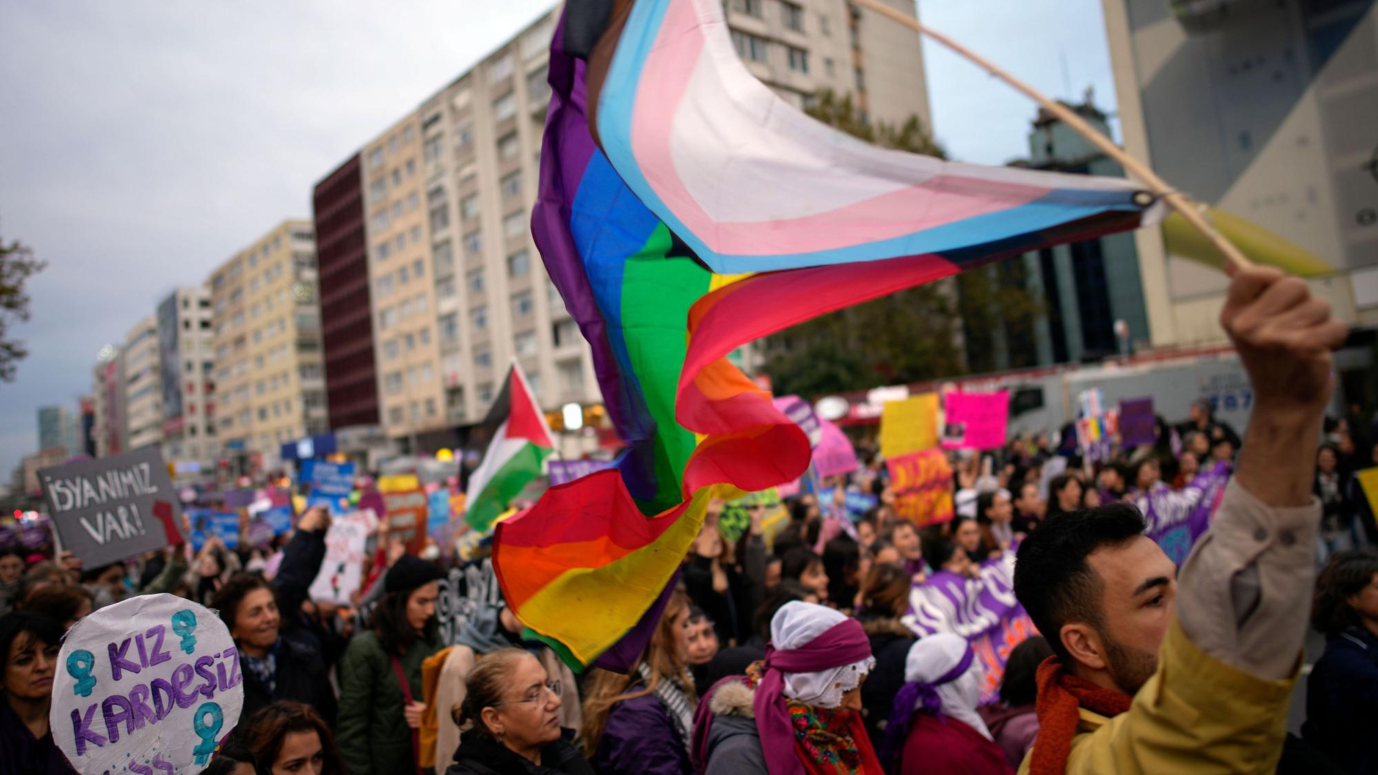 Ein Mann schwenkt eine LGBT+-Fahne, während er an einer Kundgebung anlässlich des Internationalen Tages gegen Gewalt an Frauen teilnimmt. (Archvbild)