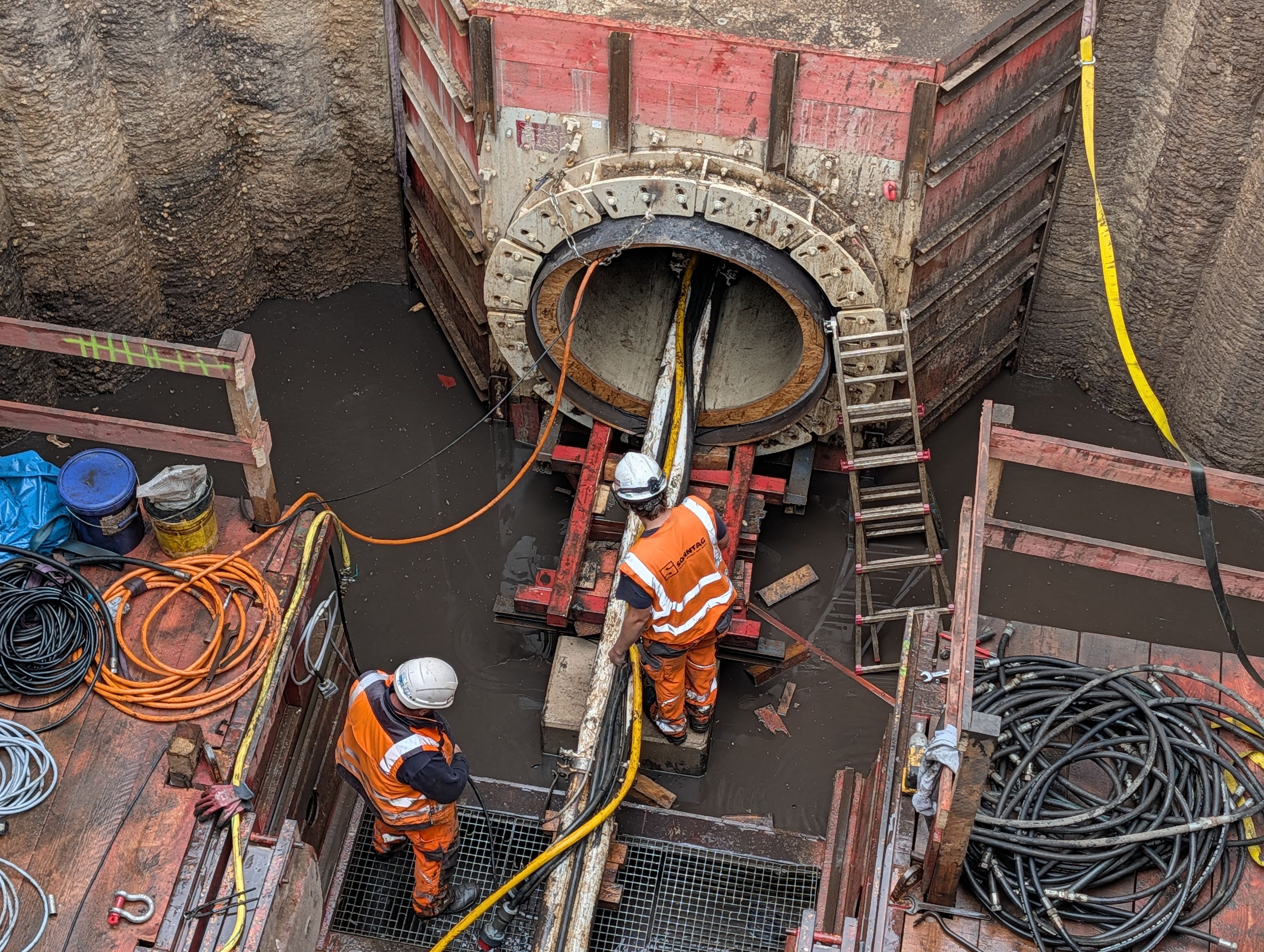 Das Foto zeigt Bauarbeiter am Ausgangspunkt des Tunnels in einem zehn Meter tiefen Schacht.
