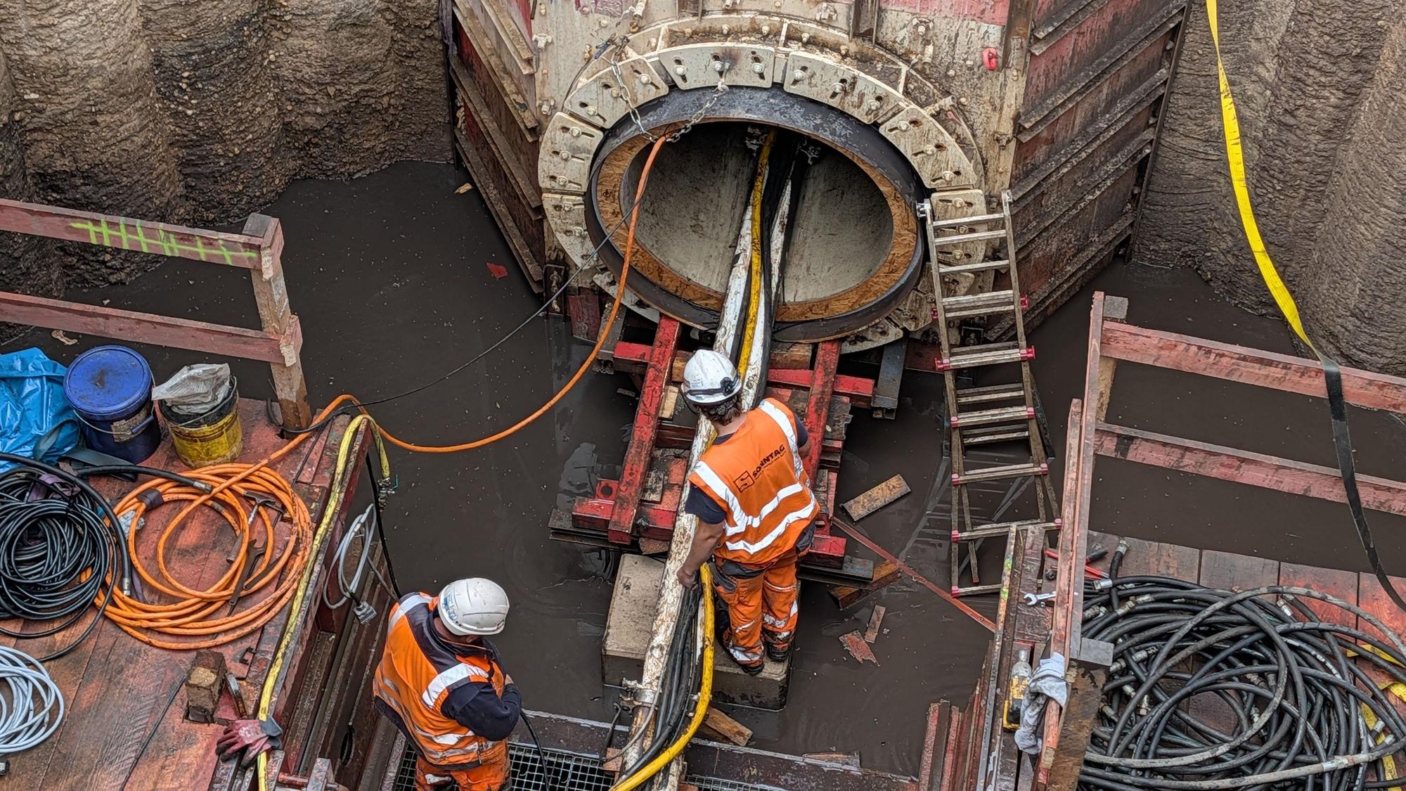 Das Foto zeigt Bauarbeiter am Ausgangspunkt des Tunnels in einem zehn Meter tiefen Schacht.