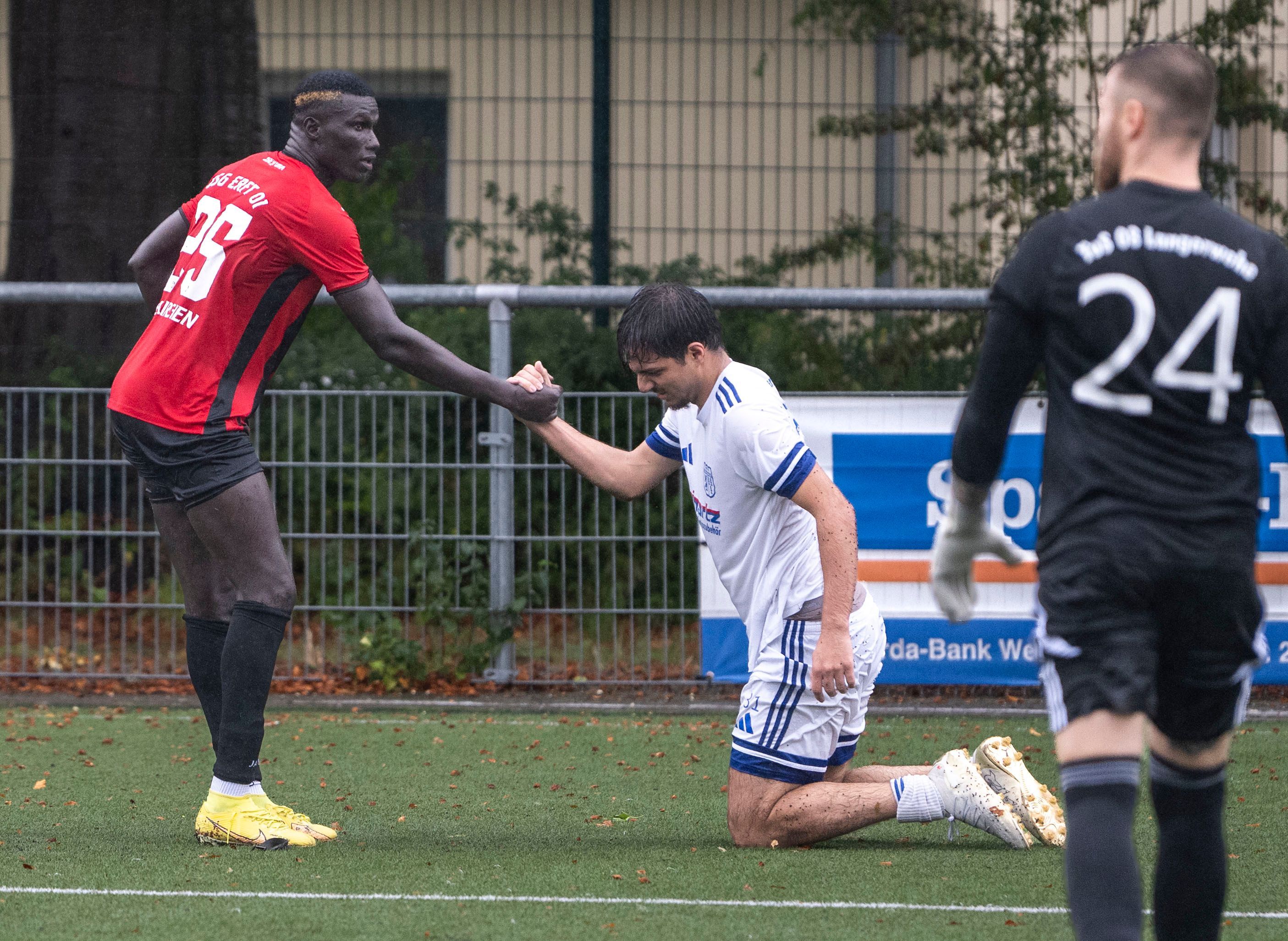 Das Bild zeigt den obgenannten Fußballer, der seinem Gegenspieler wieder auf die Beine hilft.