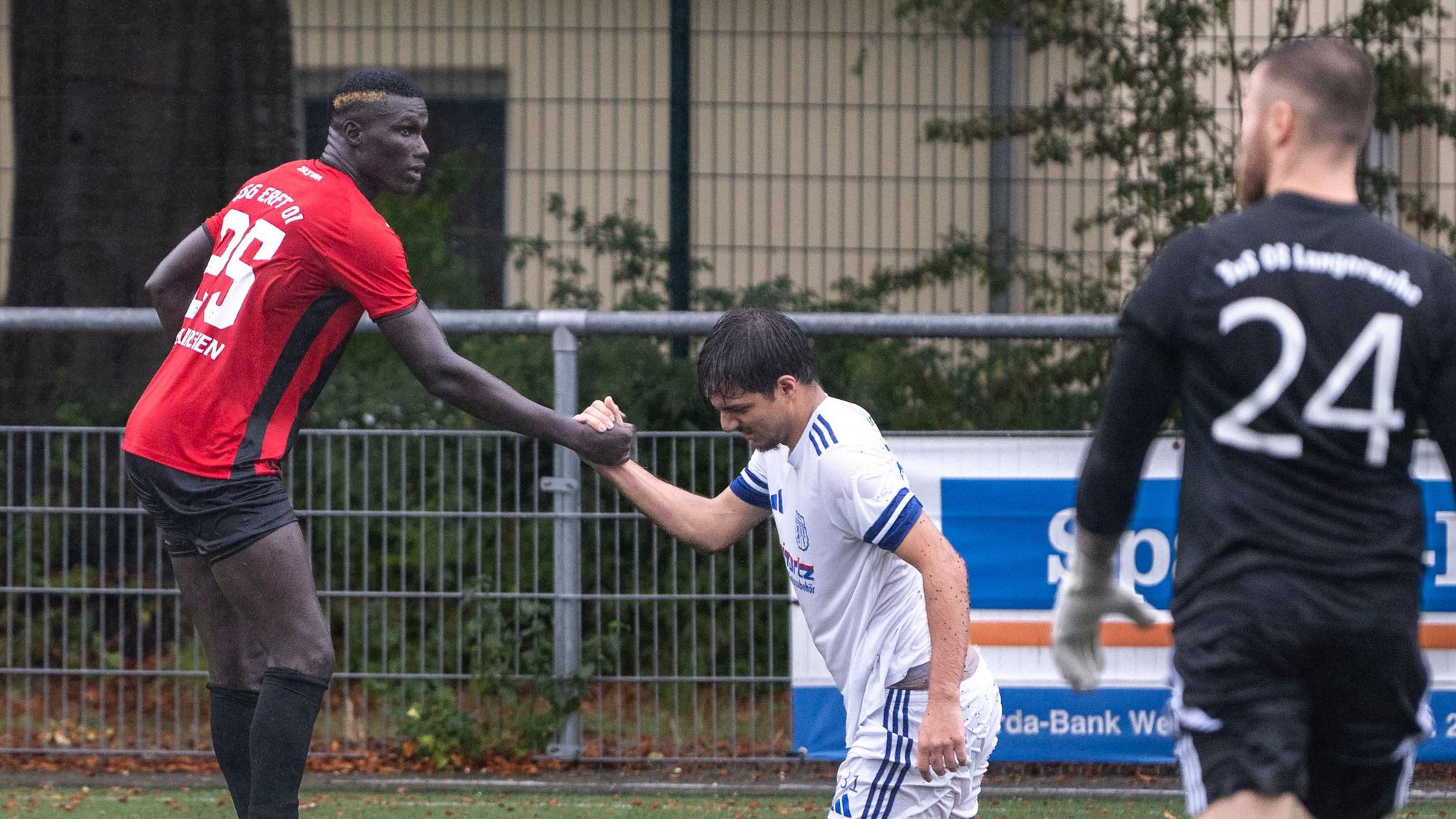 Das Bild zeigt den obgenannten Fußballer, der seinem Gegenspieler wieder auf die Beine hilft.