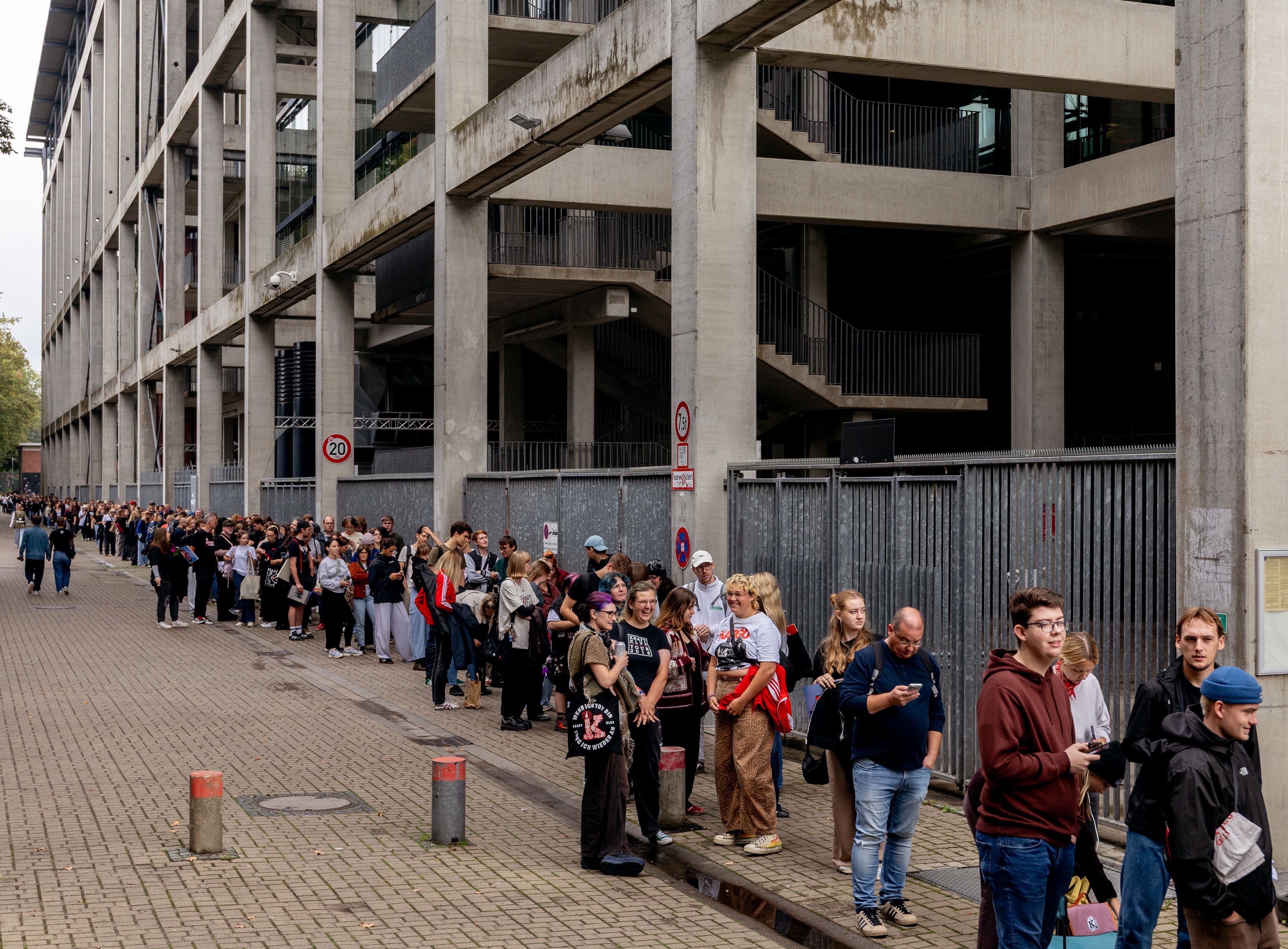 Fans warten in einer Schlange vor dem Kölner Stadion.