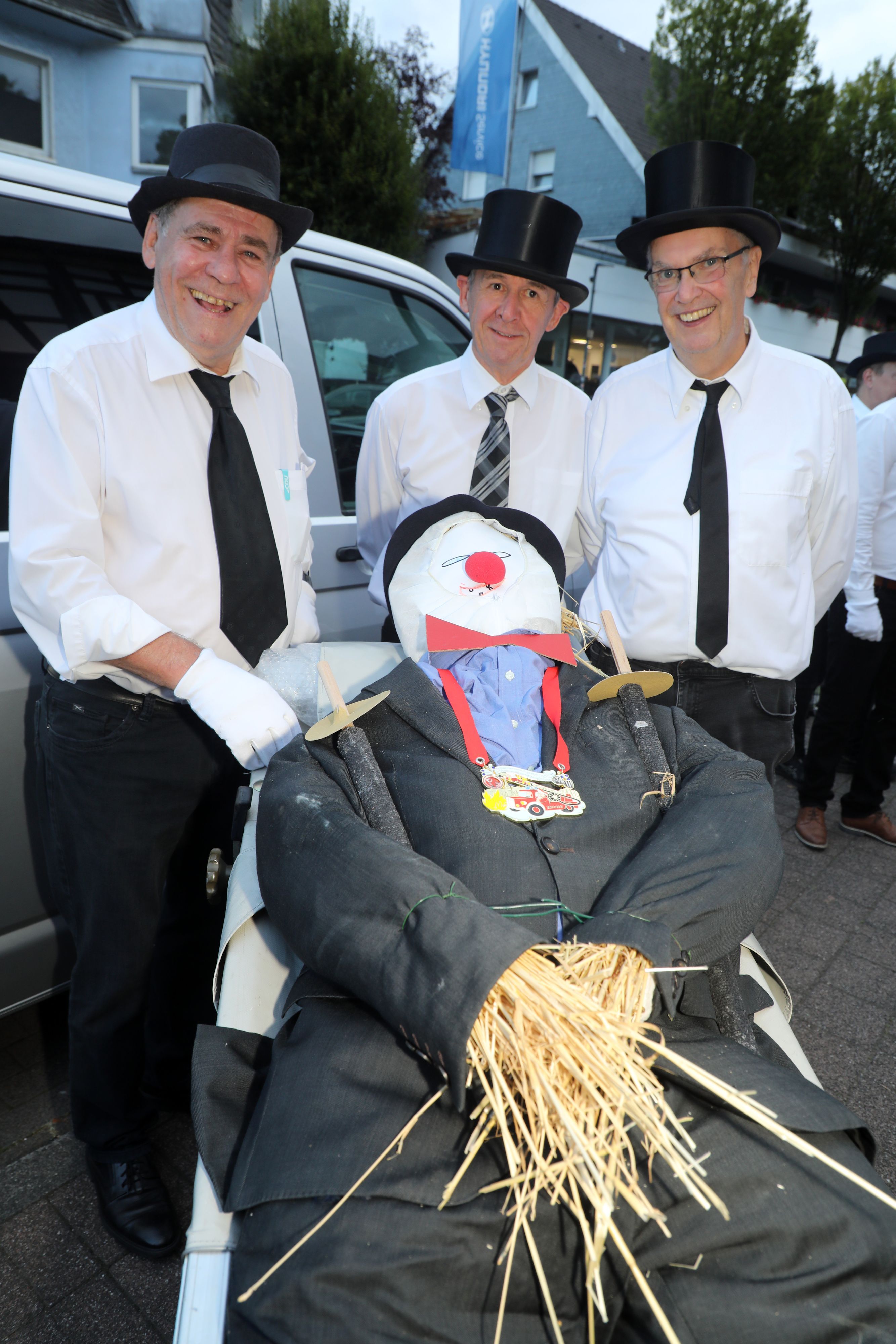 Friedel Brenner, Micky Sülz und Benedikt Promberger stehen hinter der Trage mit dem Overather Nubbel.