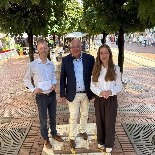 Auf dem Bild sind zwei Männer und eine Frau in der Fußgängerzone von Frechen zu sehen.