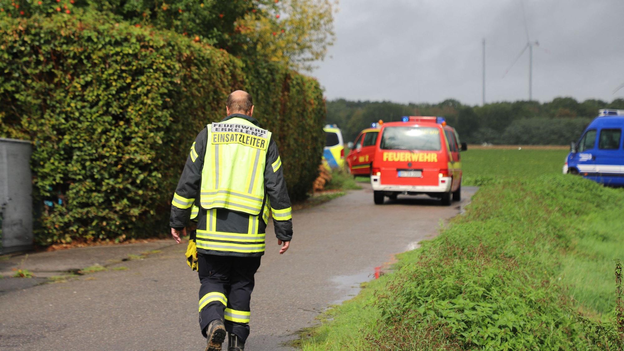 Der Einsatzleiter der Feuerwehr geht in Richtung des Absturzortes des Kleinflugzeugs in Erkelenz.