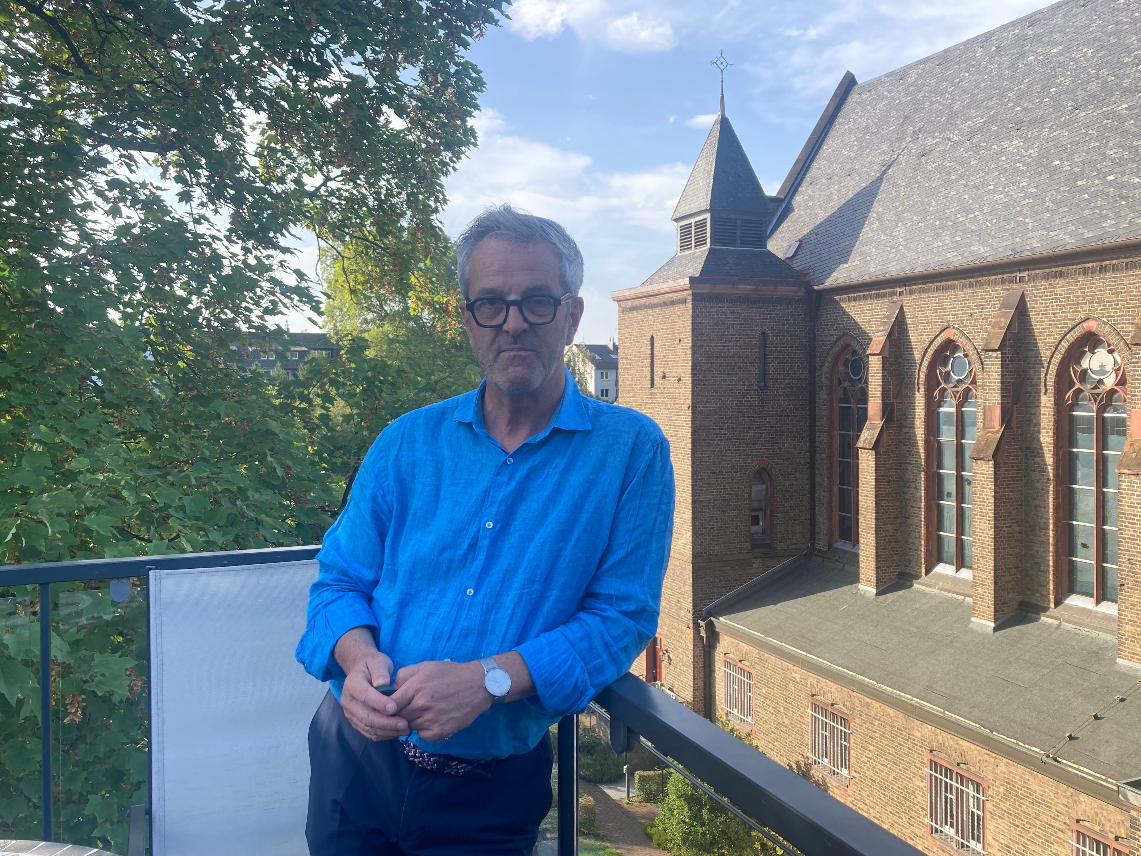 Ehemaliger Pfarrer und Mieter der Benediktinerinnen: Thomas Frings auf dem kleinen Balkon des Rektoratsgebäudes mit Blick auf das imposante Kloster und Kirchengebäude.