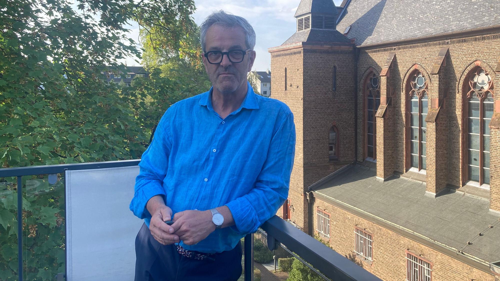 Ehemaliger Pfarrer und Mieter der Benediktinerinnen: Thomas Frings auf dem kleinen Balkon des Rektoratsgebäudes mit Blick auf das imposante Kloster und Kirchengebäude.