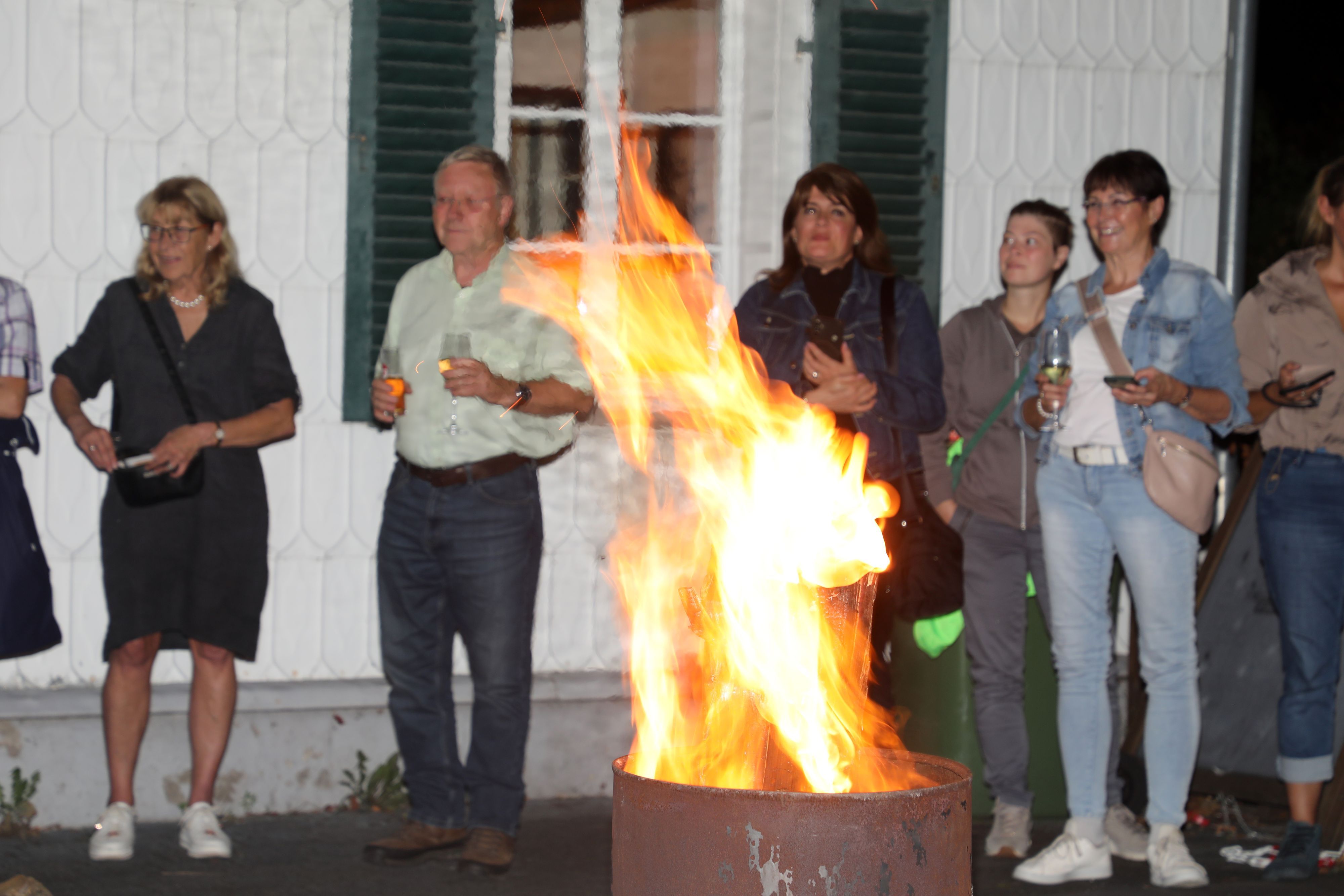 Menschen stehen um eine Feuertonne am Dom-Hotel in Overath.