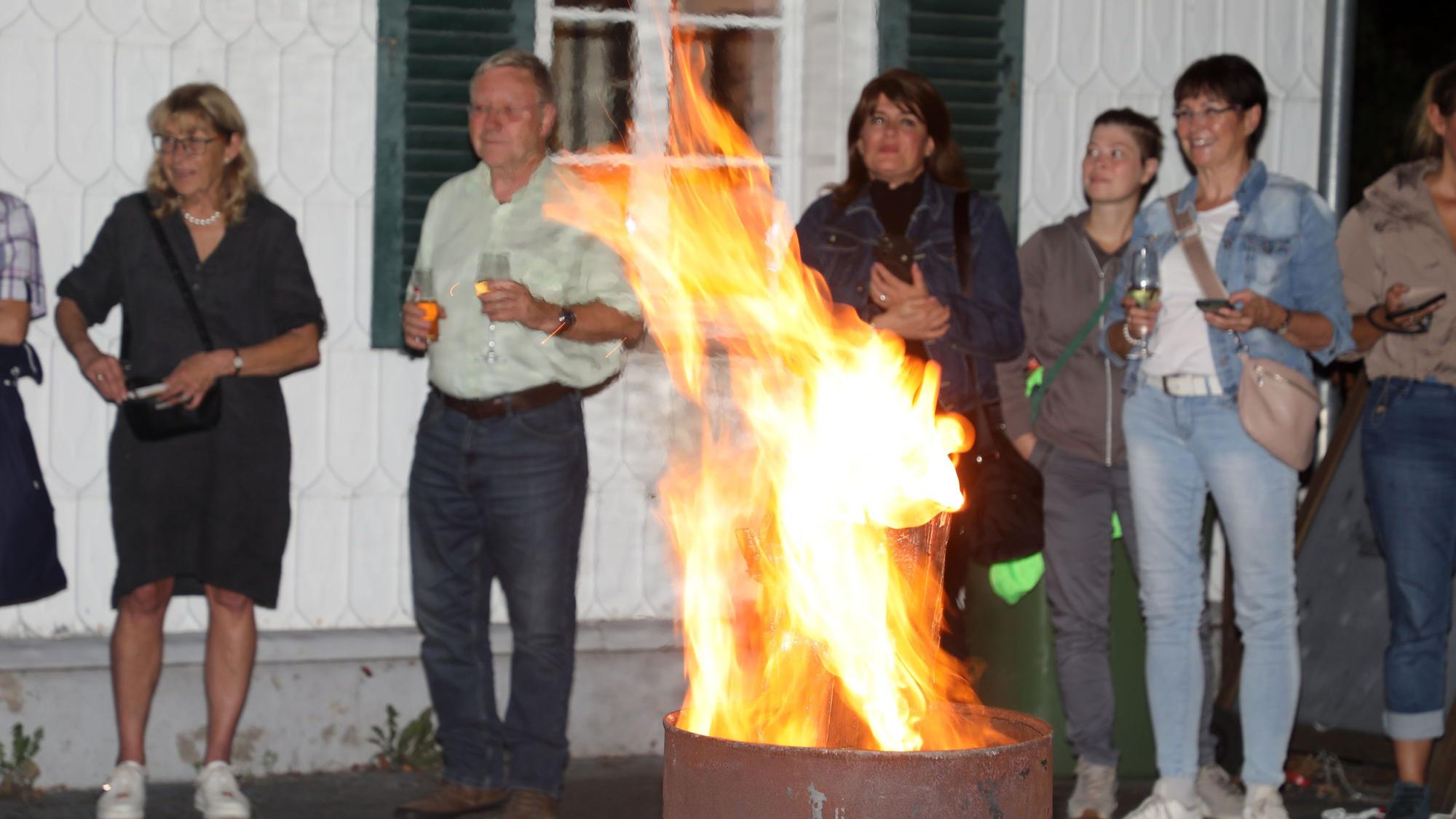 Menschen stehen um eine Feuertonne am Dom-Hotel in Overath.