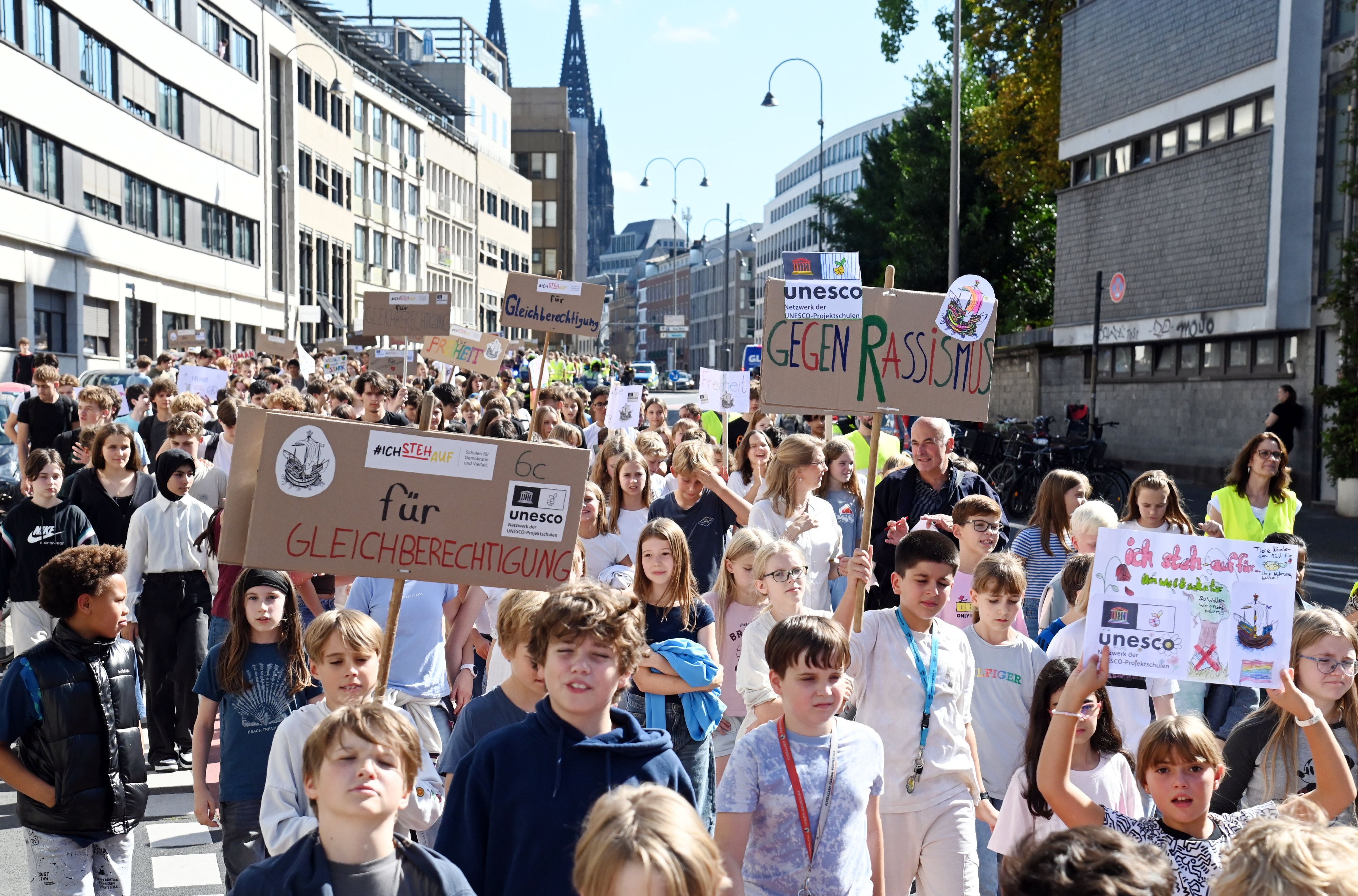 Schülerinnen und Schüler des Hansa-Gymnasiums halten bei einer Demo in der Kölner Innenstadt Schilder hoch.