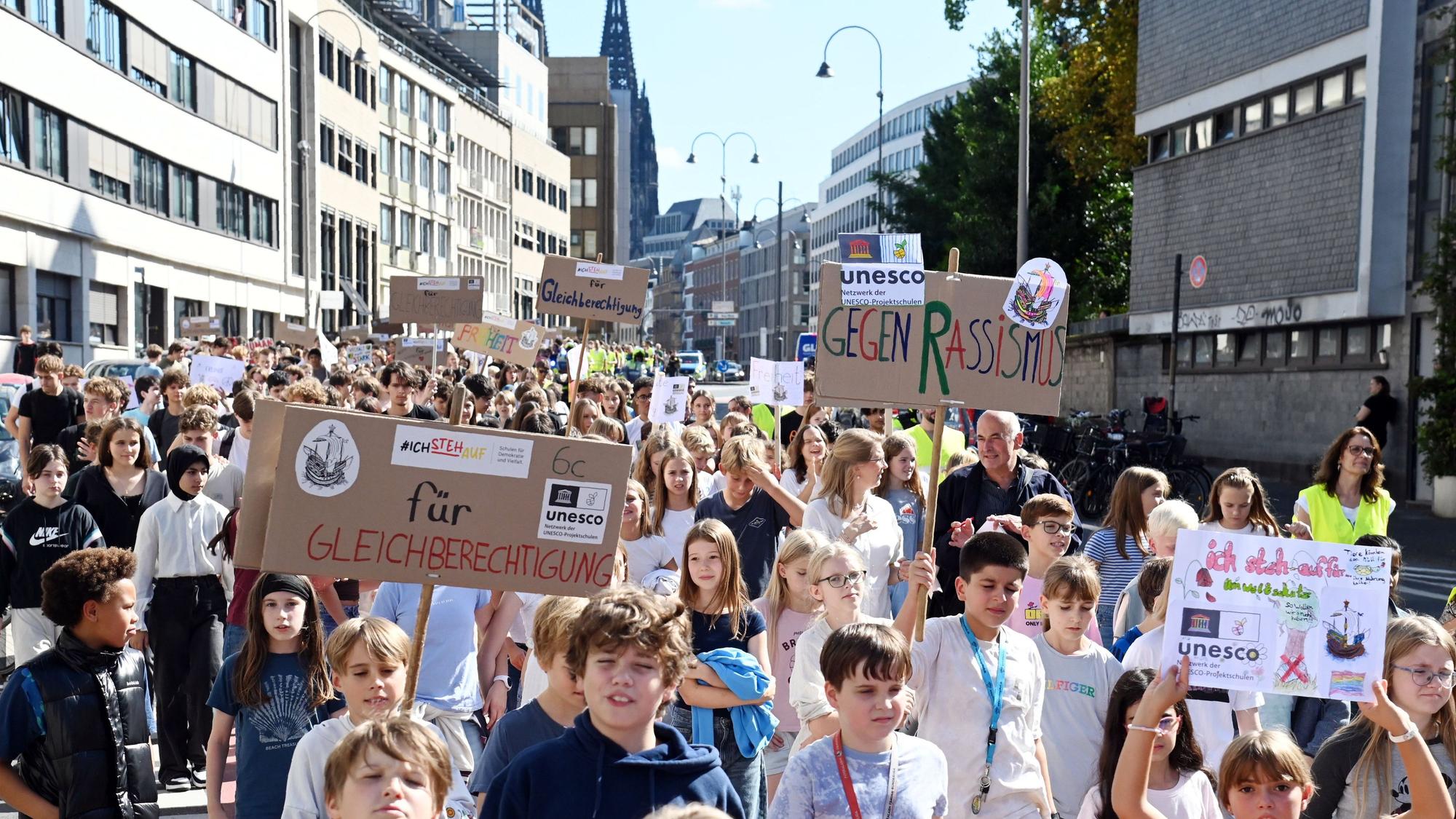 Schülerinnen und Schüler des Hansa-Gymnasiums halten bei einer Demo in der Kölner Innenstadt Schilder hoch.