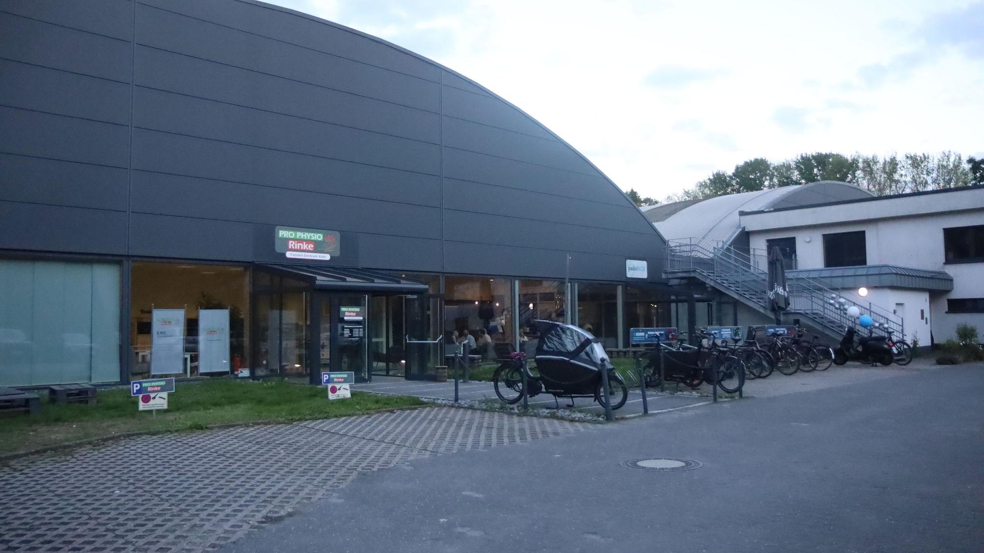 Eine Halle mit einem Anbau ist zu sehen.