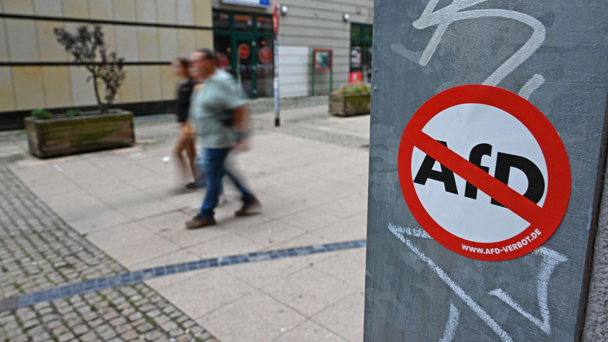 Ein Aufkleber mit der Aufschrift „www.AfD-Verbot.de“ hängt an einem Masten.