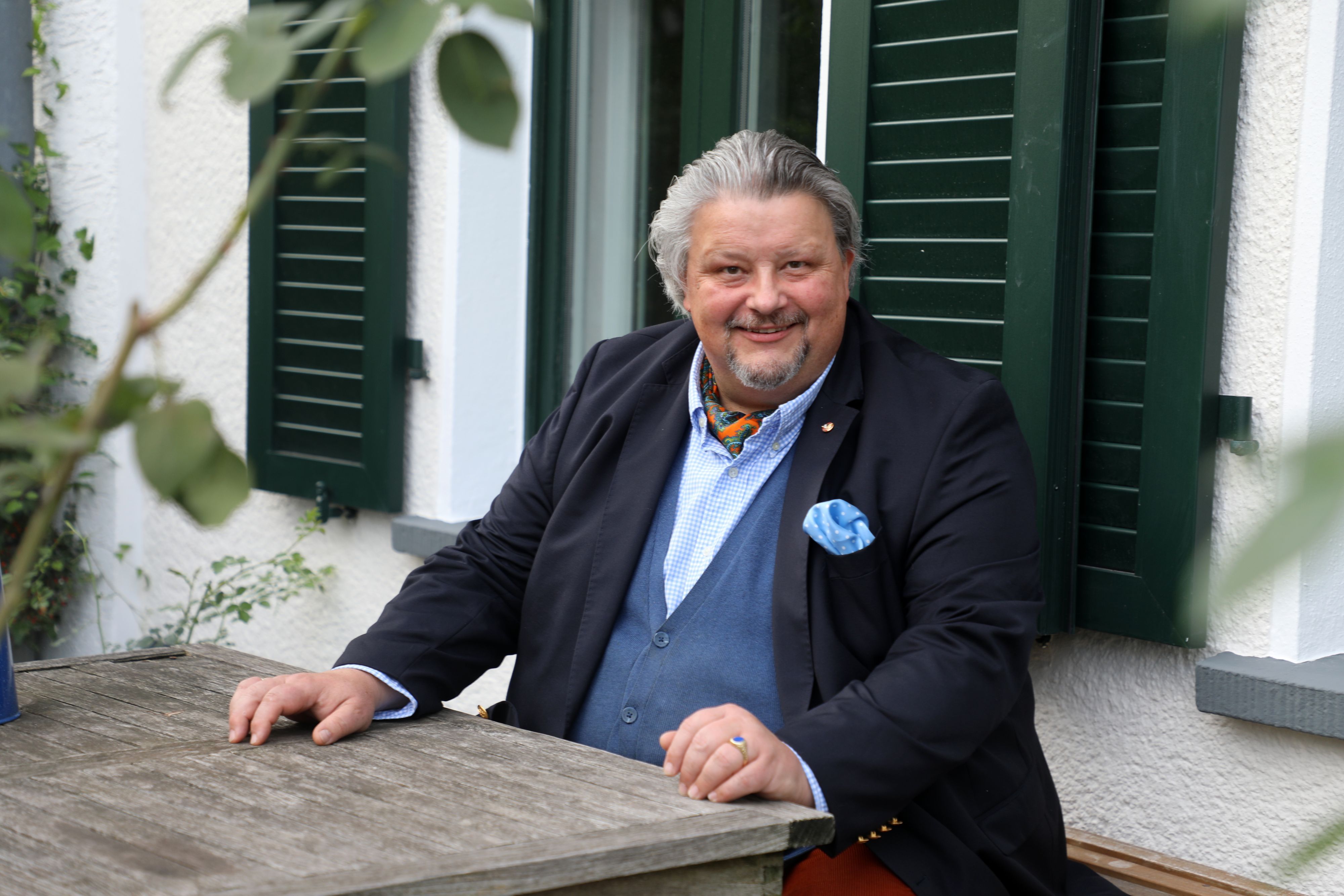 Thomas Cüpper sitzt auf der Bank vor seinem Haus in Bergisch Gladbach-Sand.