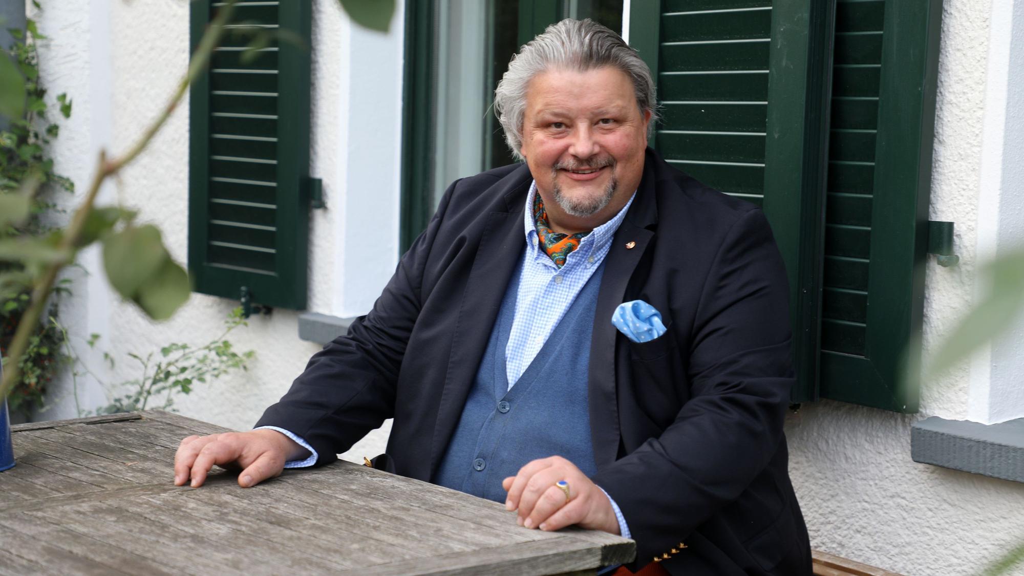 Thomas Cüpper sitzt auf der Bank vor seinem Haus in Bergisch Gladbach-Sand.
