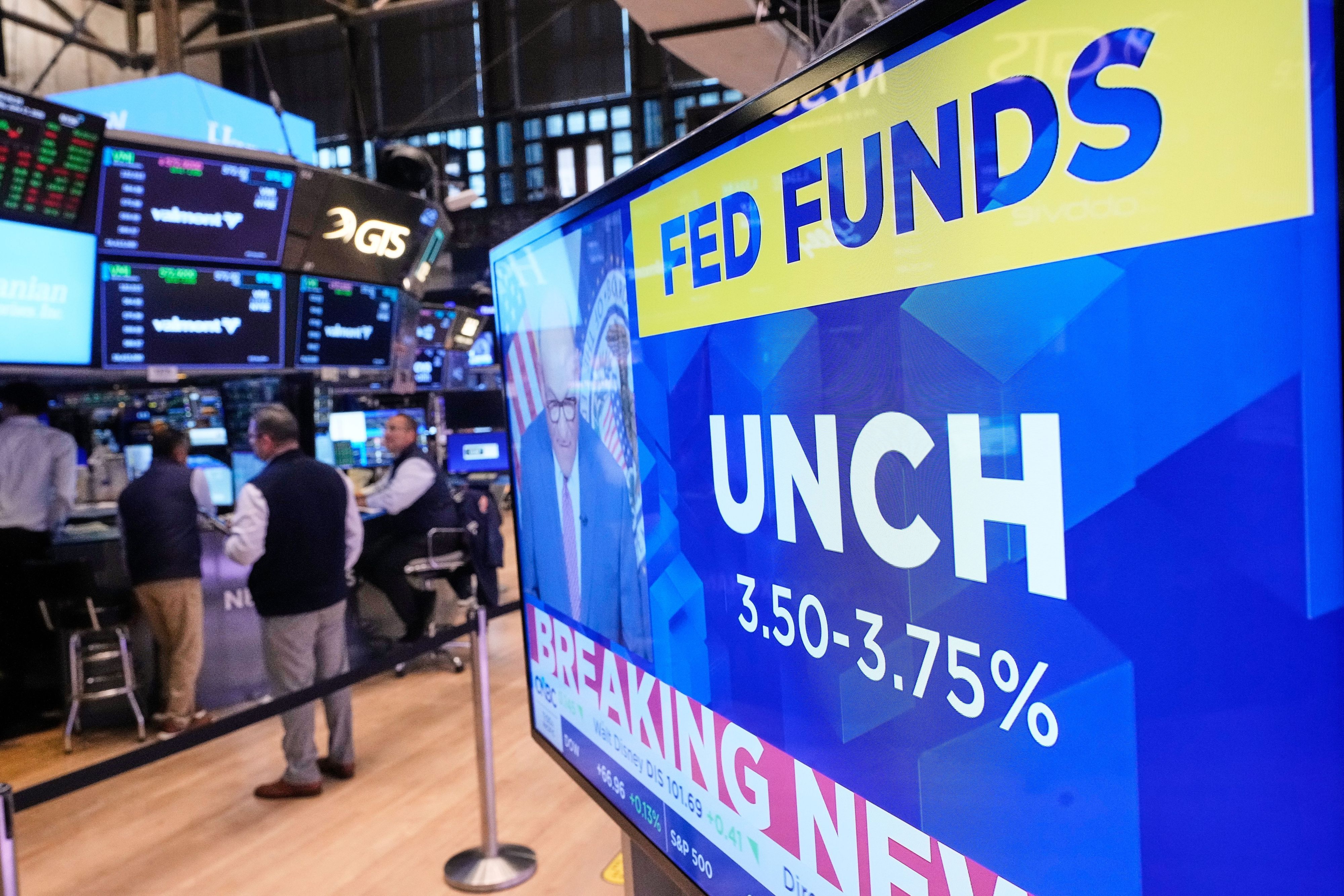 Ein blauer Fernsehbildschirm im Handelssaal der New Yorker Börse zeigt die Sätze des Leitzinses, bevor die US-Notenbank am Mittwochabend ihre Zinsen erhöht hat.