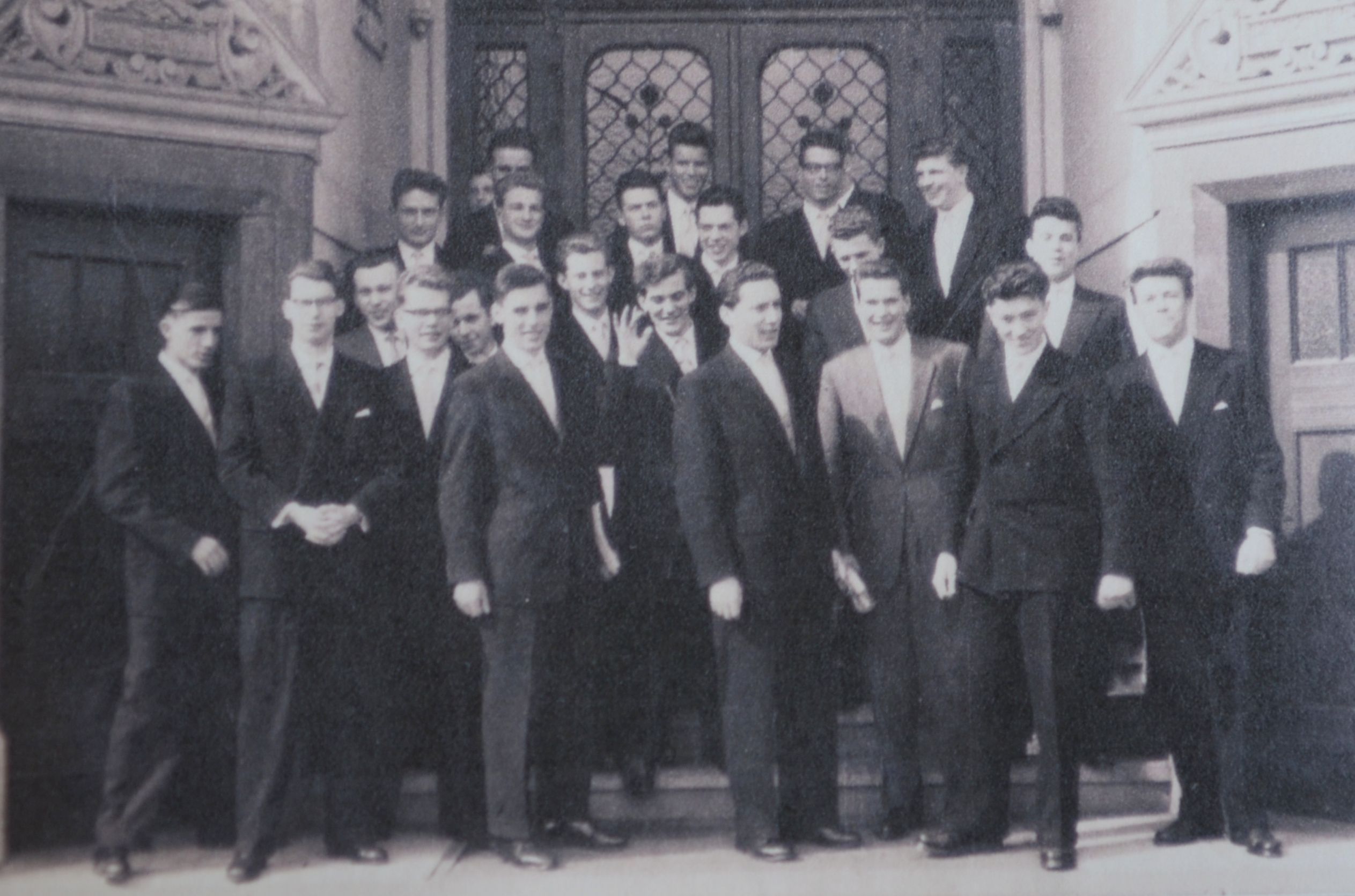 Die Abiturienten von 1958 stehen auf Treppenstufen, sie tragen dunkle Anzüge.