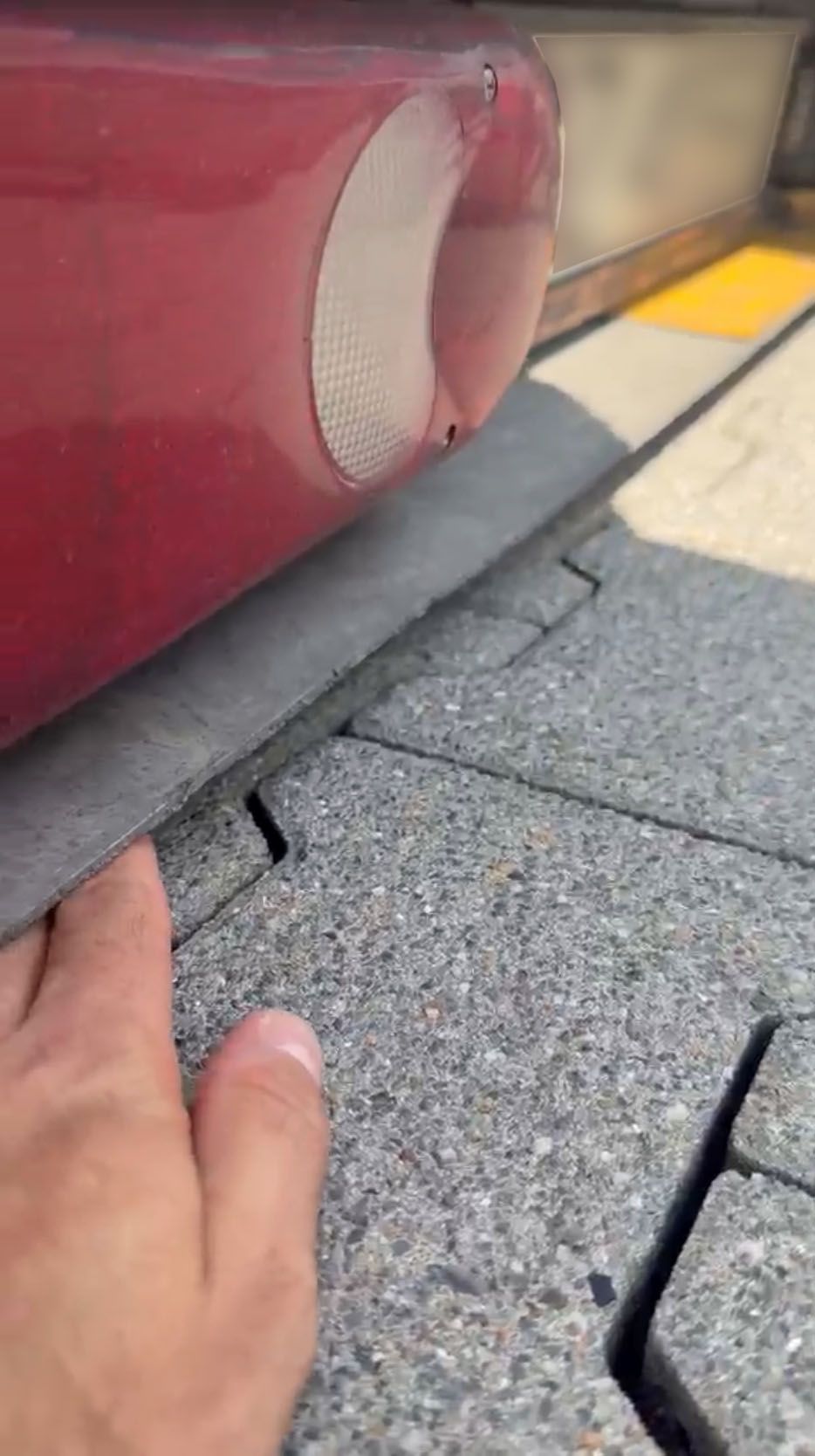 Ein Polizeibeamter hält eine Hand unter das Auto, um zu zeigen, wie tief der Transporter liegt.