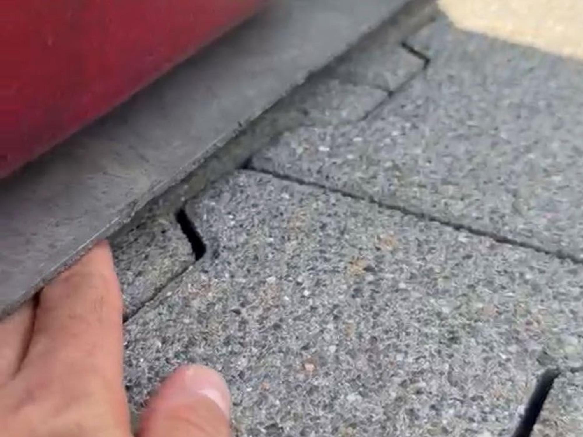 Ein Polizeibeamter hält eine Hand unter das Auto, um zu zeigen, wie tief der Transporter liegt.