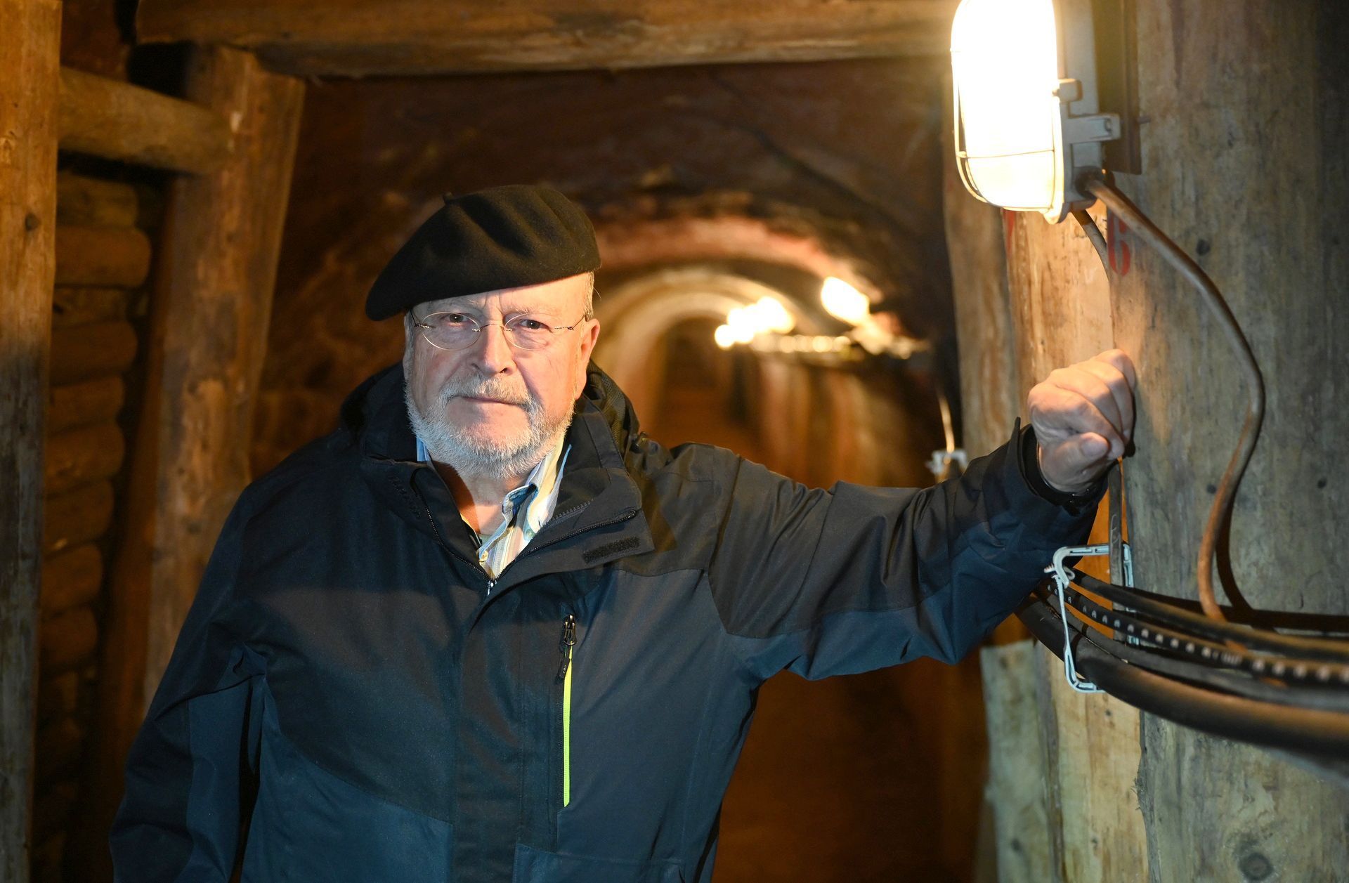 Autor Manfred Lang in einem Stollen des ehemaligen Bleibergwerks in Mechernich. Er trägt eine Baskenmütze und eine dunkle Funktionsjacke.