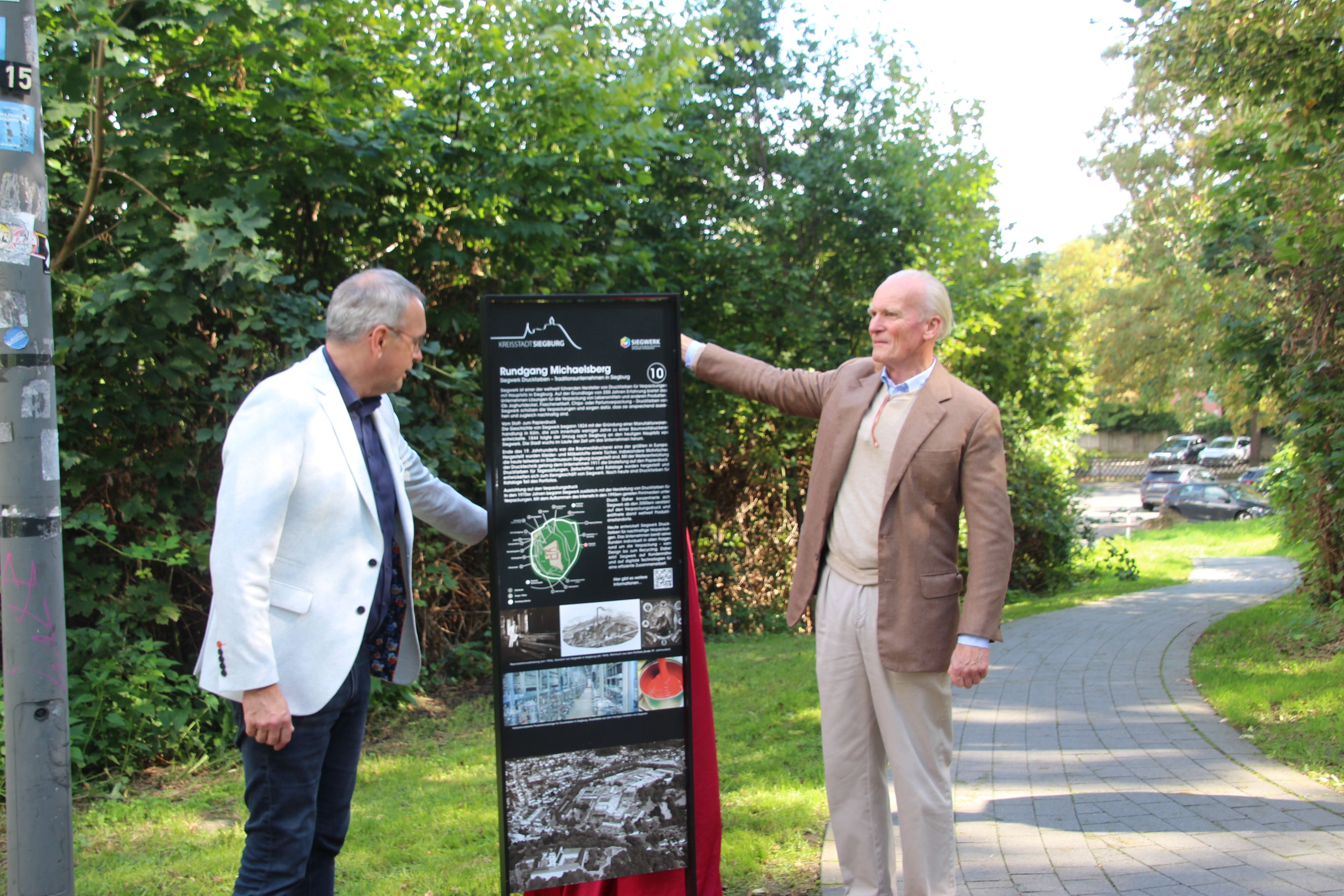 Bürgermeister Stefan Rosemann (l.) und Siegwerk-Eigentümer Alfred Keller bei der Enthüllung einer der 16 vom Siegwerk gestifteten Stelen rund um den Michaelsberg.