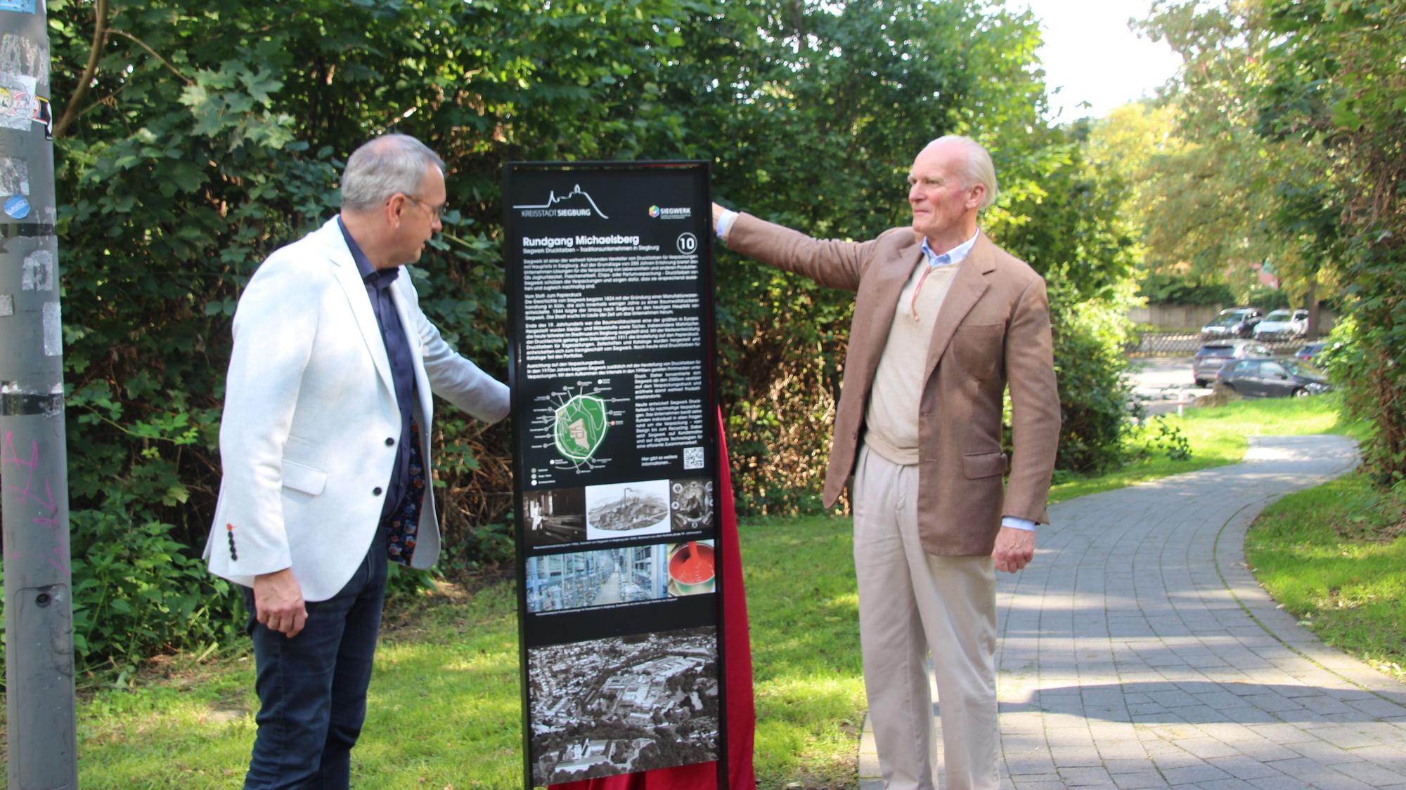 Bürgermeister Stefan Rosemann (l.) und Siegwerk-Eigentümer Alfred Keller bei der Enthüllung einer der 16 vom Siegwerk gestifteten Stelen rund um den Michaelsberg.