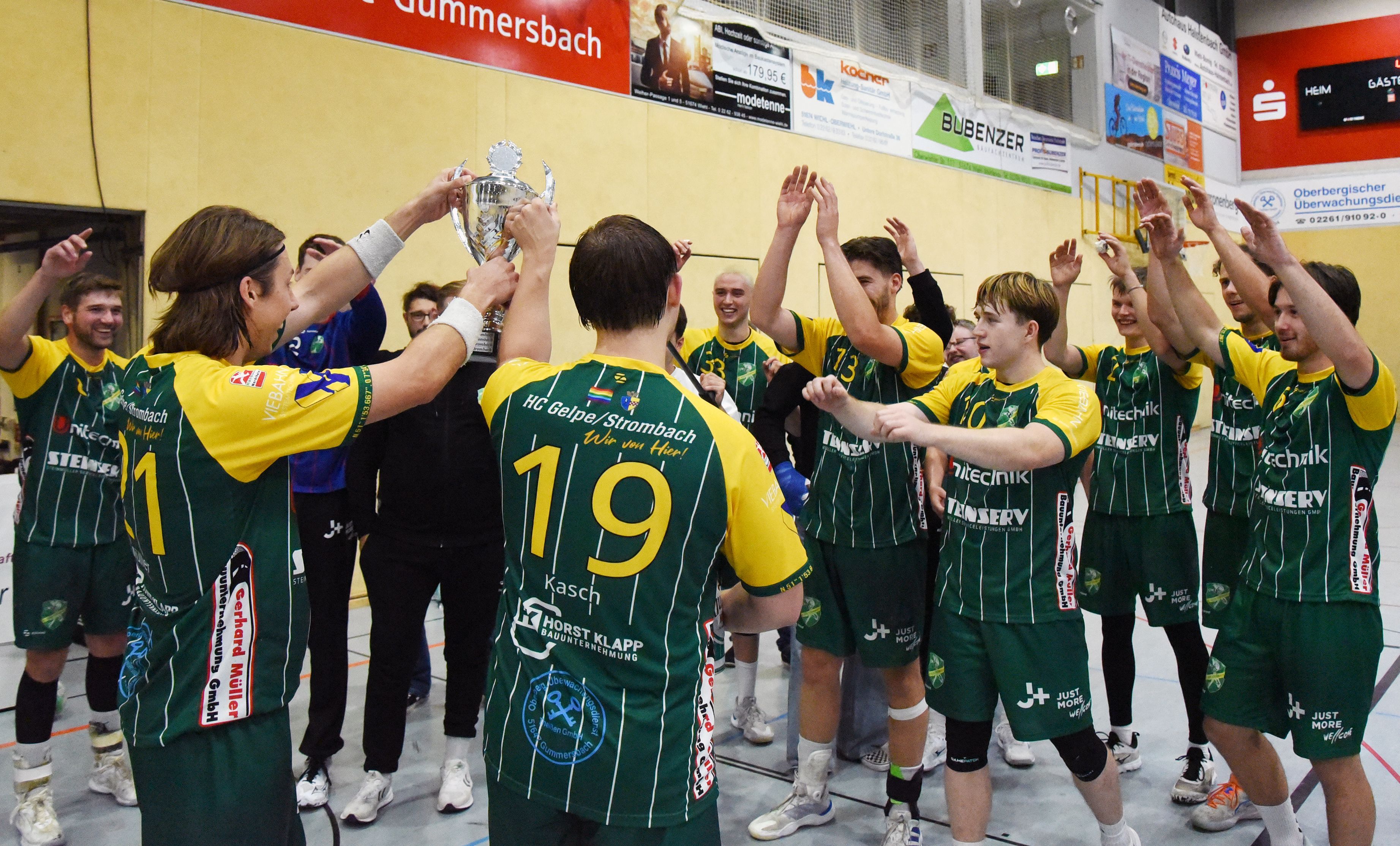 Die Handballer des HC Gelpe/Strombach jubeln mit dem Pokal.