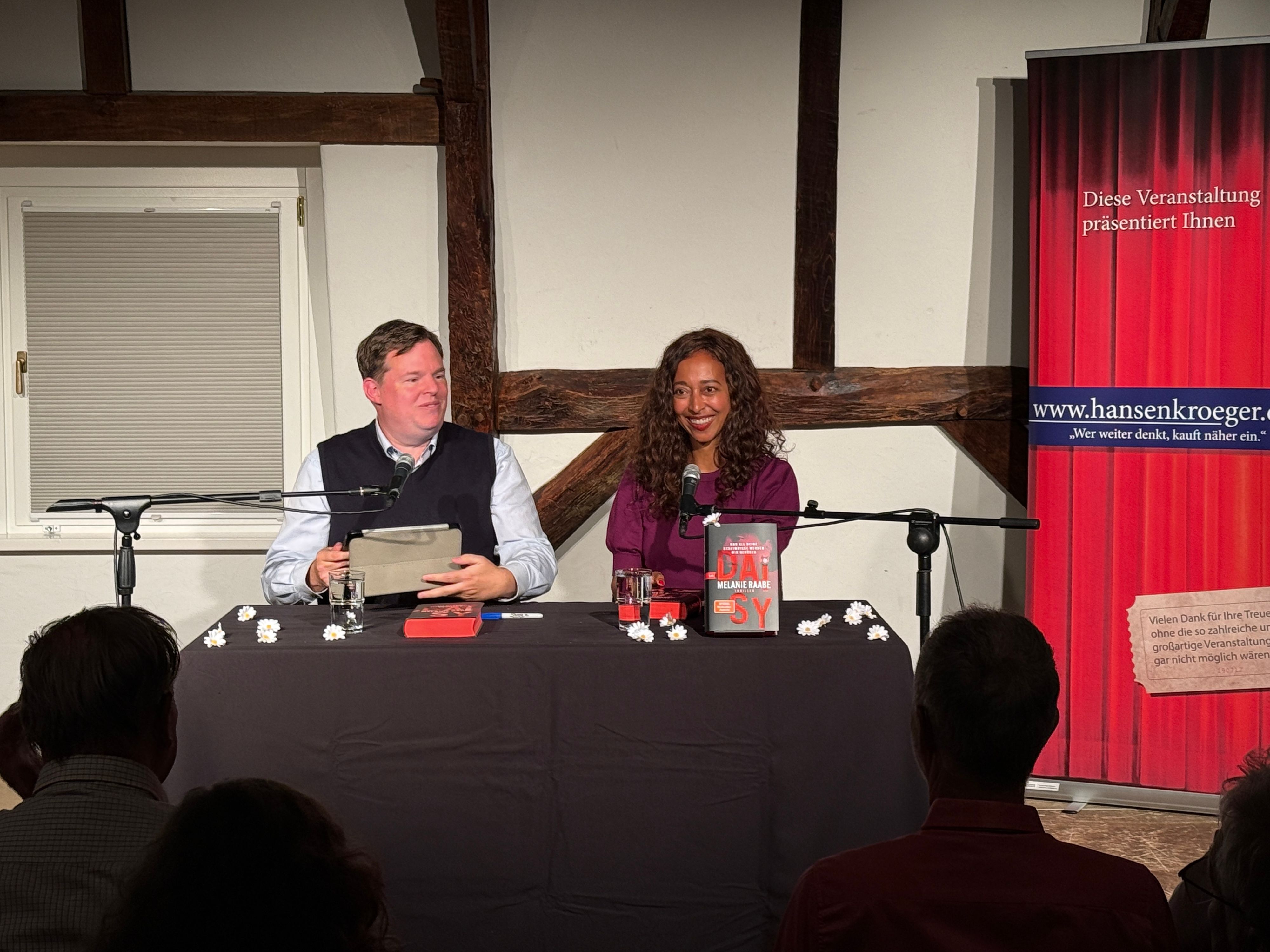 Autorin Melanie Raabe und Buchhändler Mike Altwicker sitzen nebeneinander.