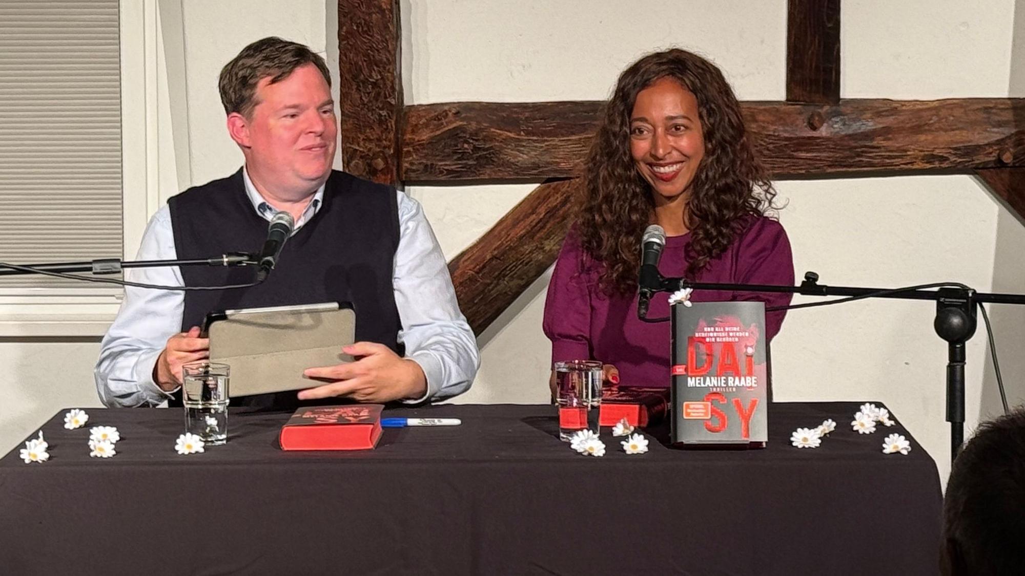 Autorin Melanie Raabe und Buchhändler Mike Altwicker sitzen nebeneinander.