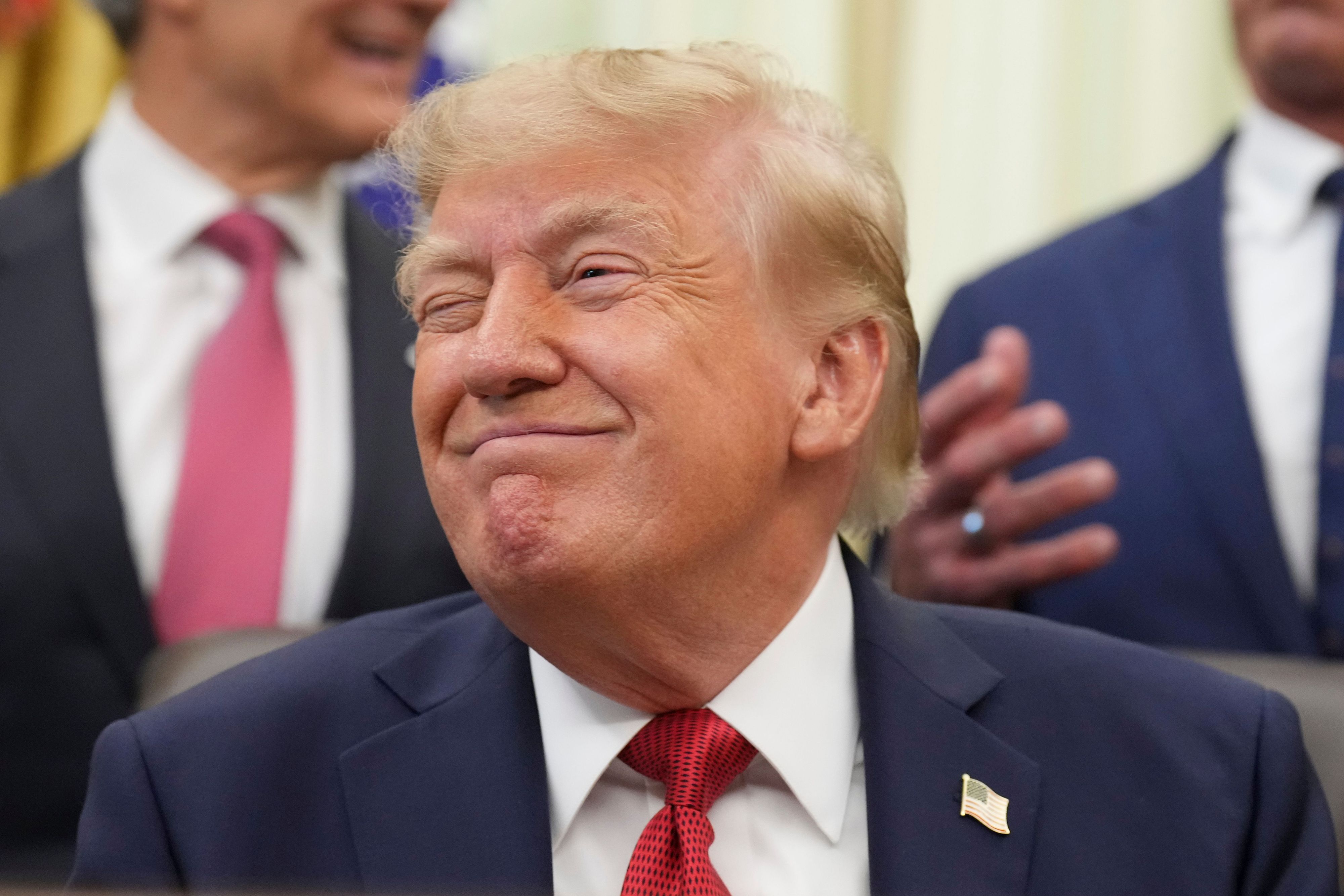 Donald Trump grinst bei einer Veranstaltung im Oval Office.